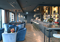 Das Atlantic-Hotel in Münster - de Skybar mit einer langen Theke und gemütlichen blauen Sesseln