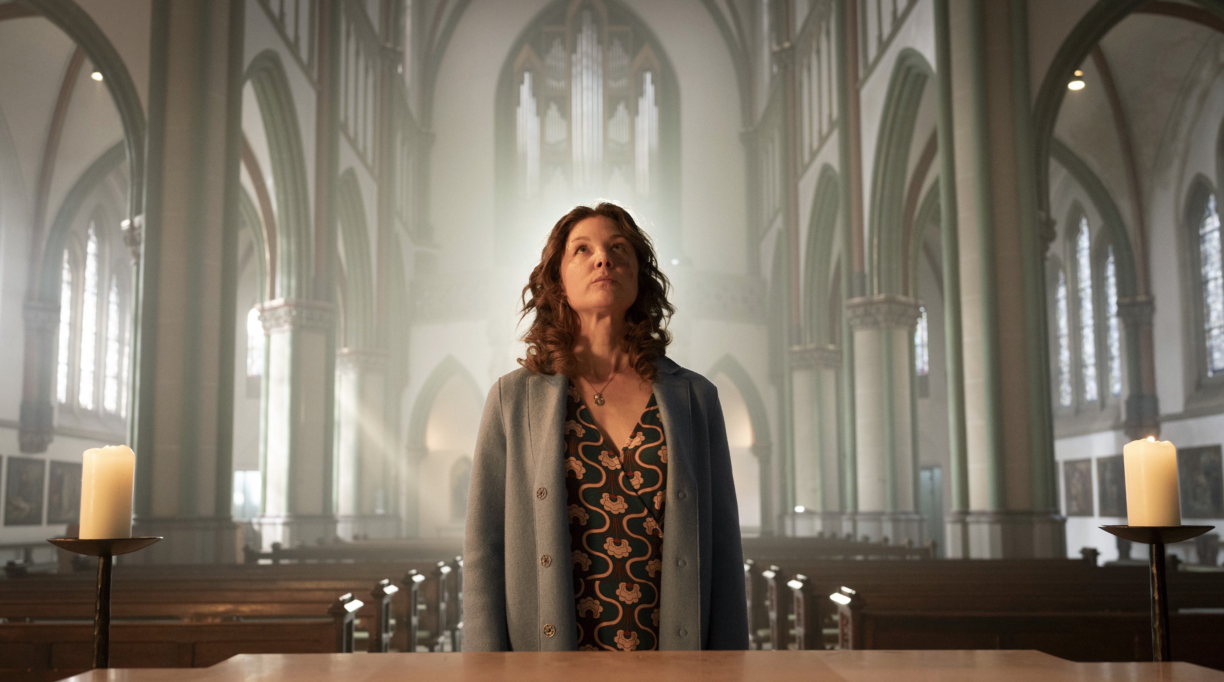 Doreen Prätorius (Cordelia Wege) steht im sanften Licht der Münsteraner Heilig-Kreuz-Kirche, das durch die hohen Fenster strömt.