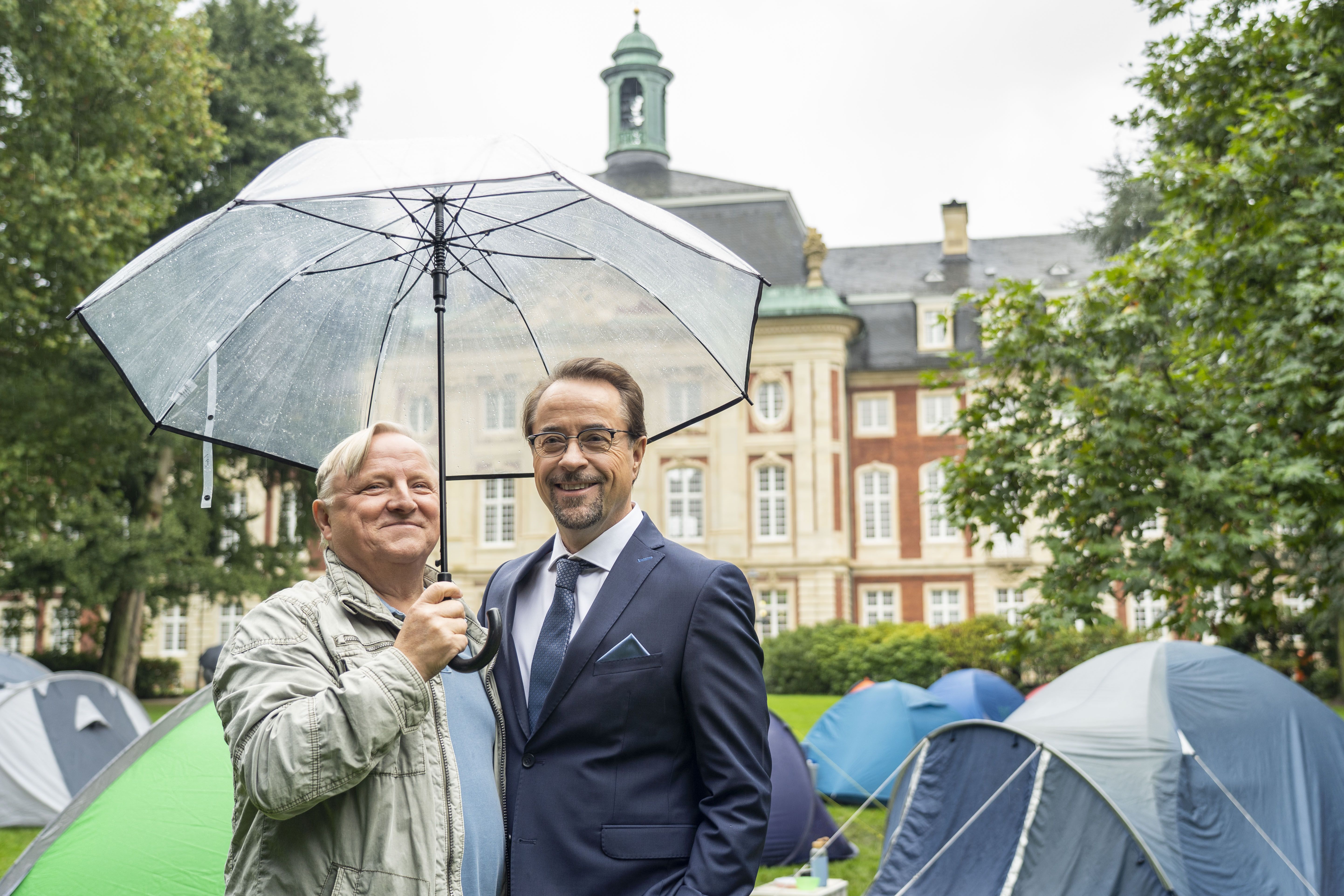 Die Hauptdarsteller Axel Prahl und Jan Josef Liefers vorm Zeltcamp hinterm Schloss.