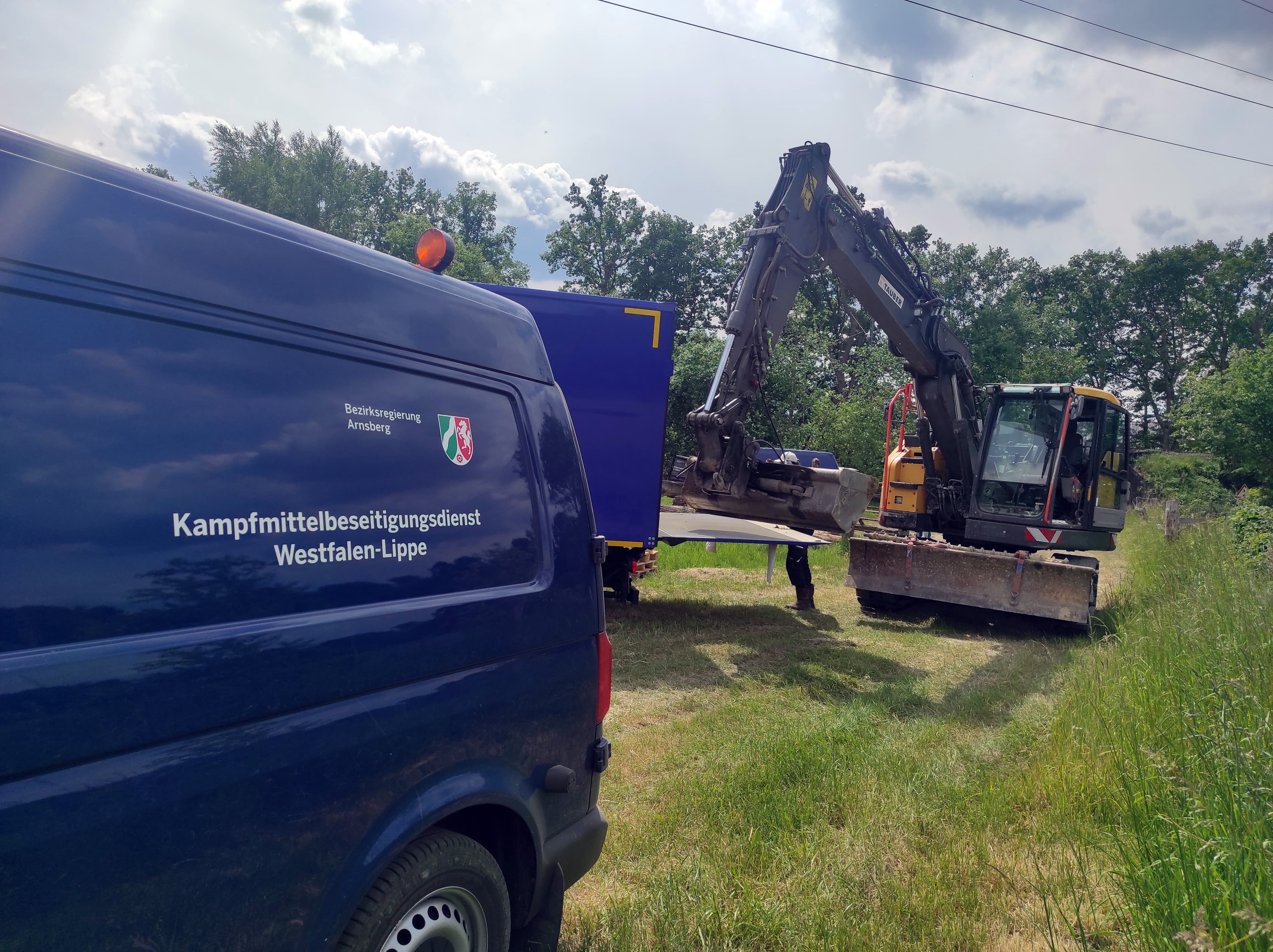 Auto des Kampfmittelbeseitigungsdienstes und Bagger im Hintergrund
