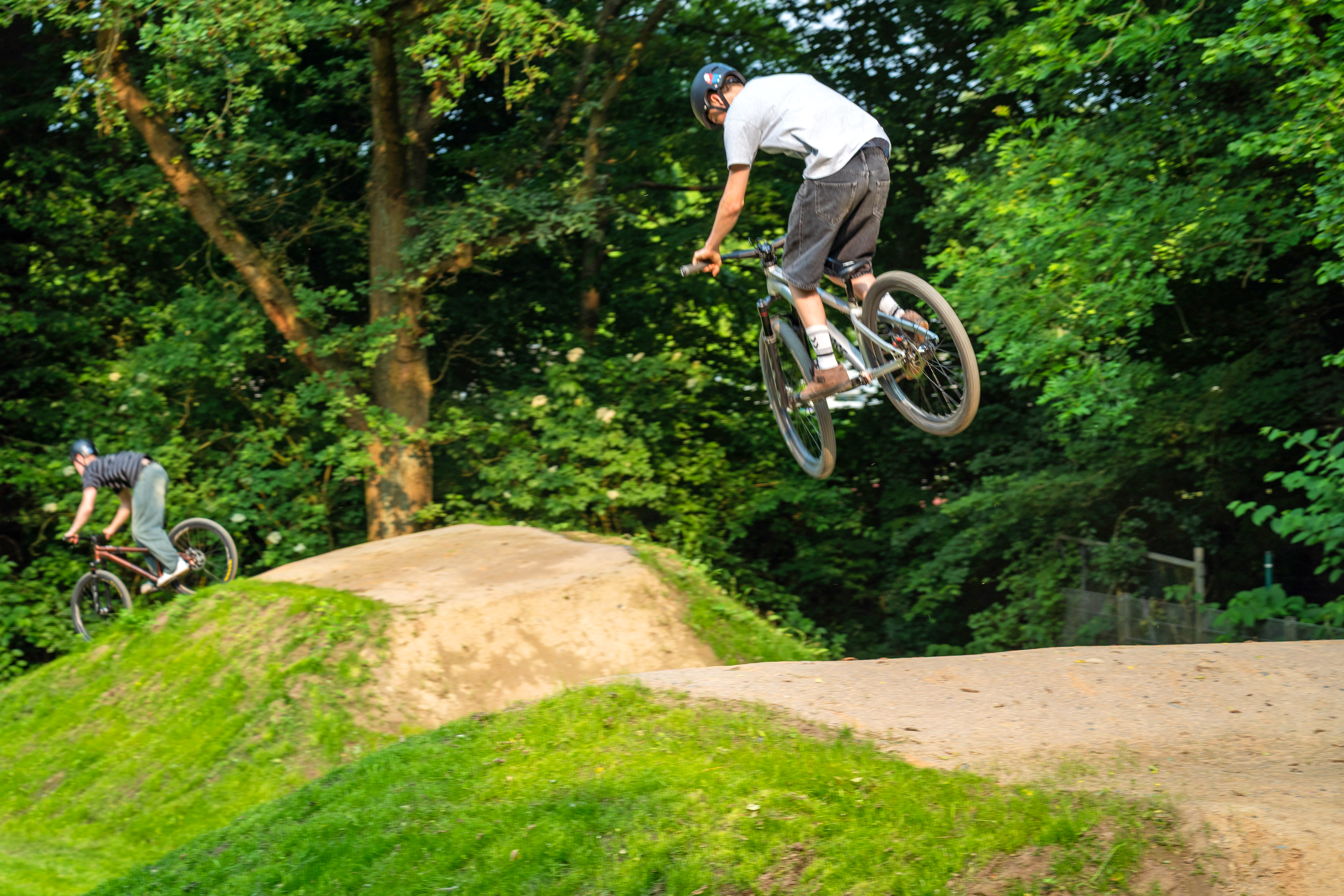 Zwei Jugendliche auf ihrem Fahrrad auf der Dirtbike-Anlage