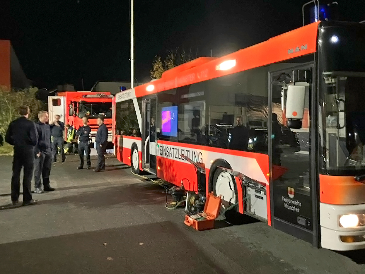 Bus mit offenen Türen und Mitarbeitende der Feuerwehr