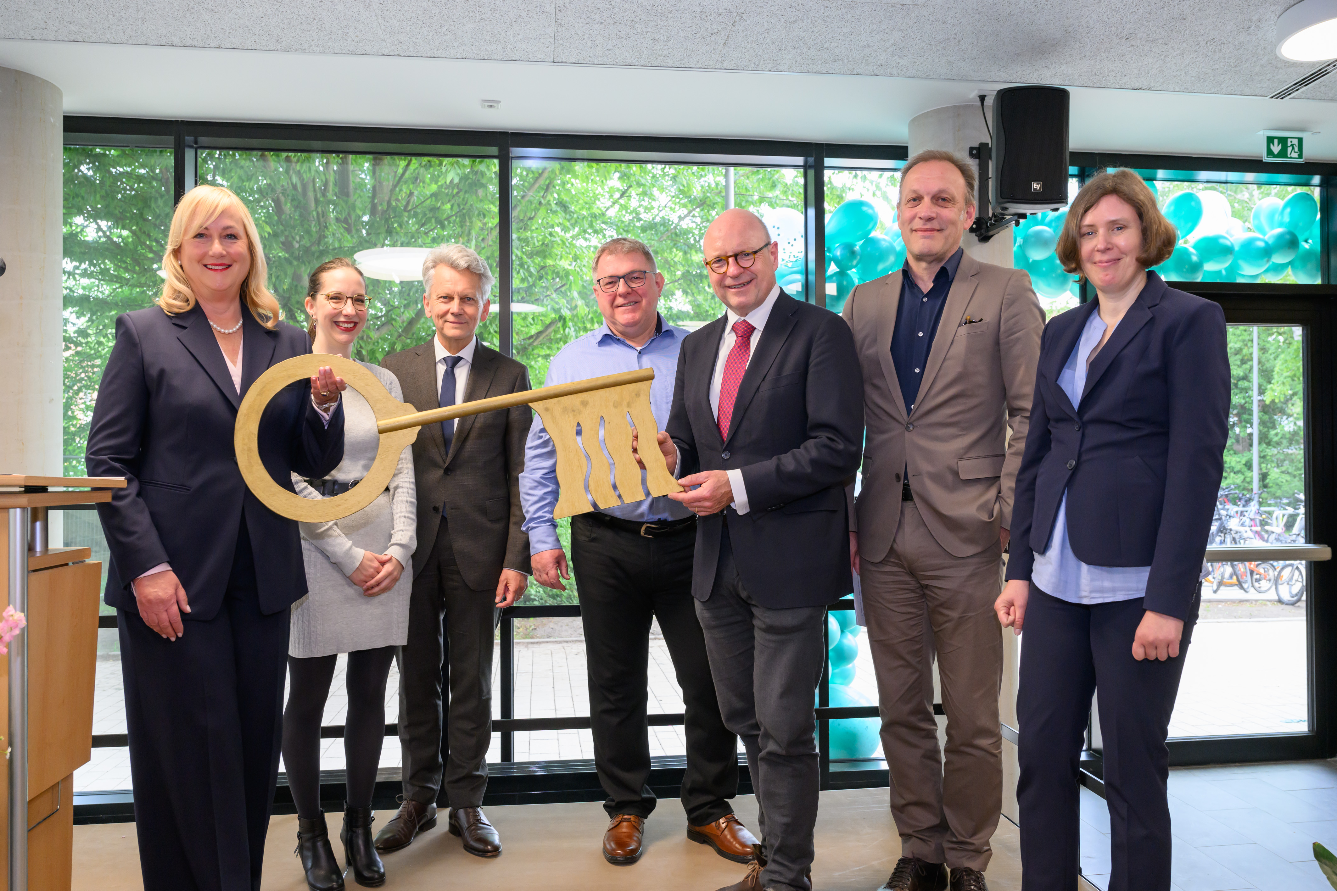 Gruppenfoto, unter anderem mit Oberbürgermeister Markus Lewe und Schulleiterin Martina Wenger, die symbolisch einen großen Schlüssel halten.