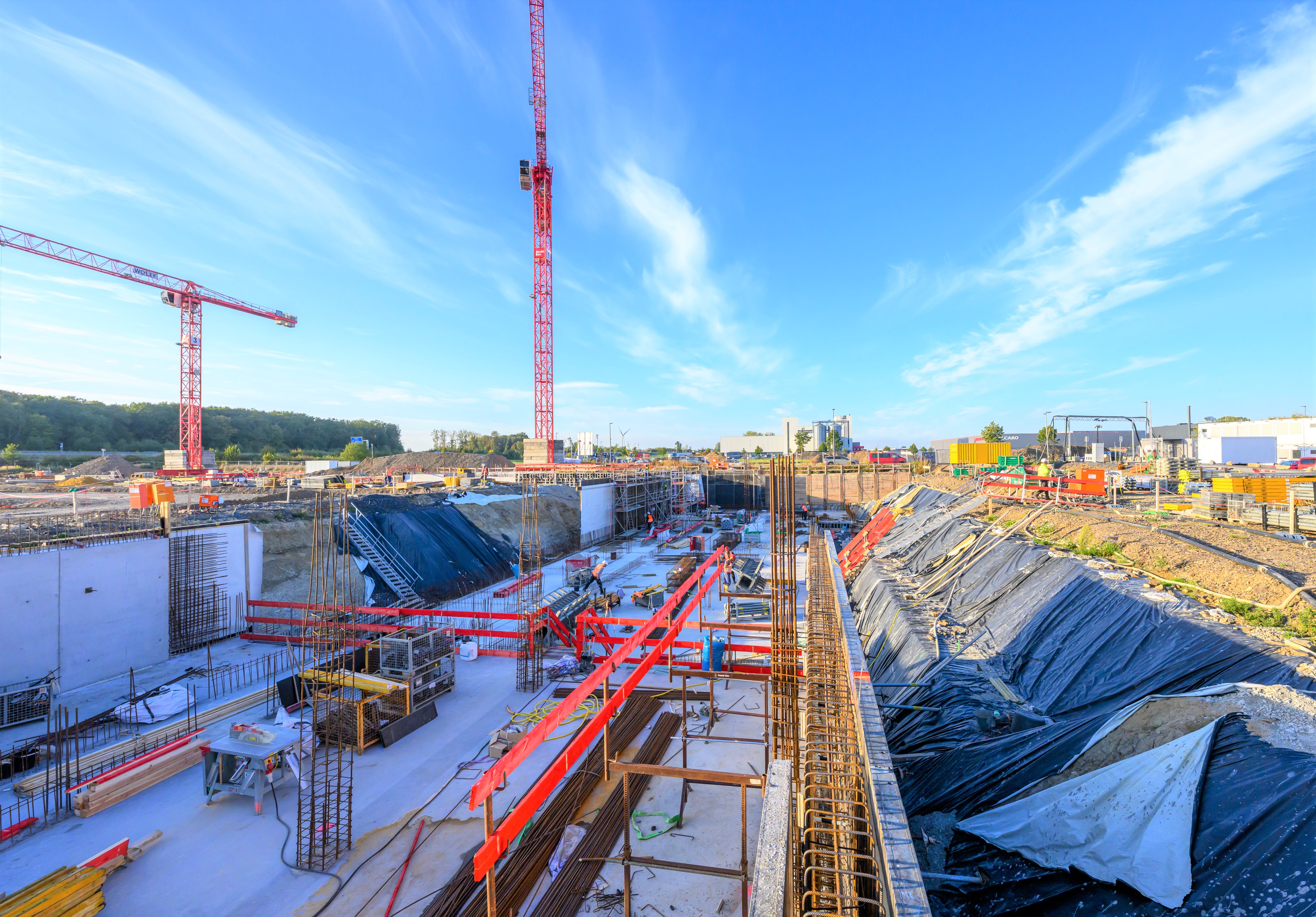 Blick auf eine Großbaustelle mit zwei Kränen