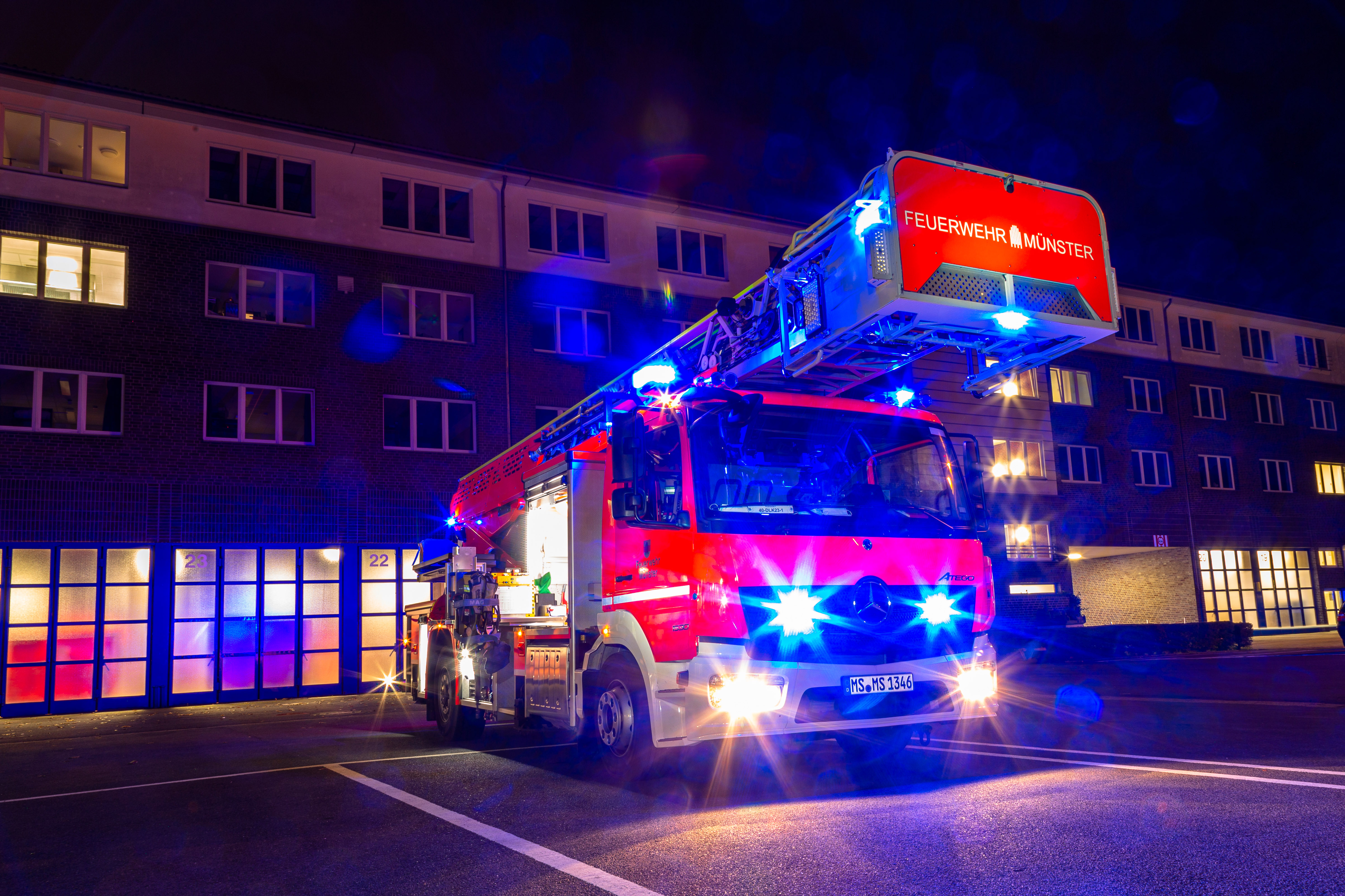 Feuerwehrauto im Einsatz, das bei Nacht aus der Feuerwache fährt