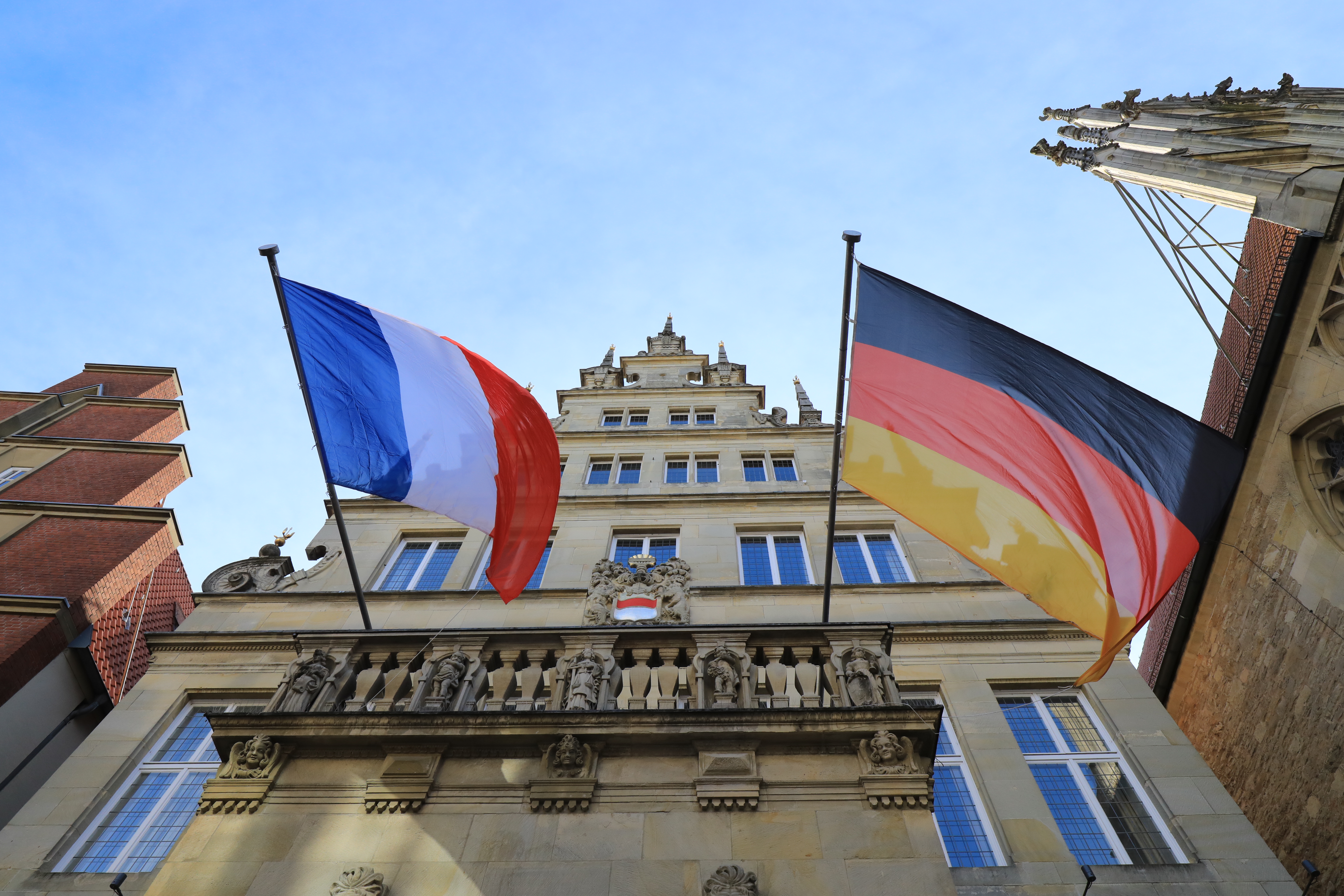Die Flagge Frankreichs und Deutschlands gehisst am historischen Rathaus in Münster