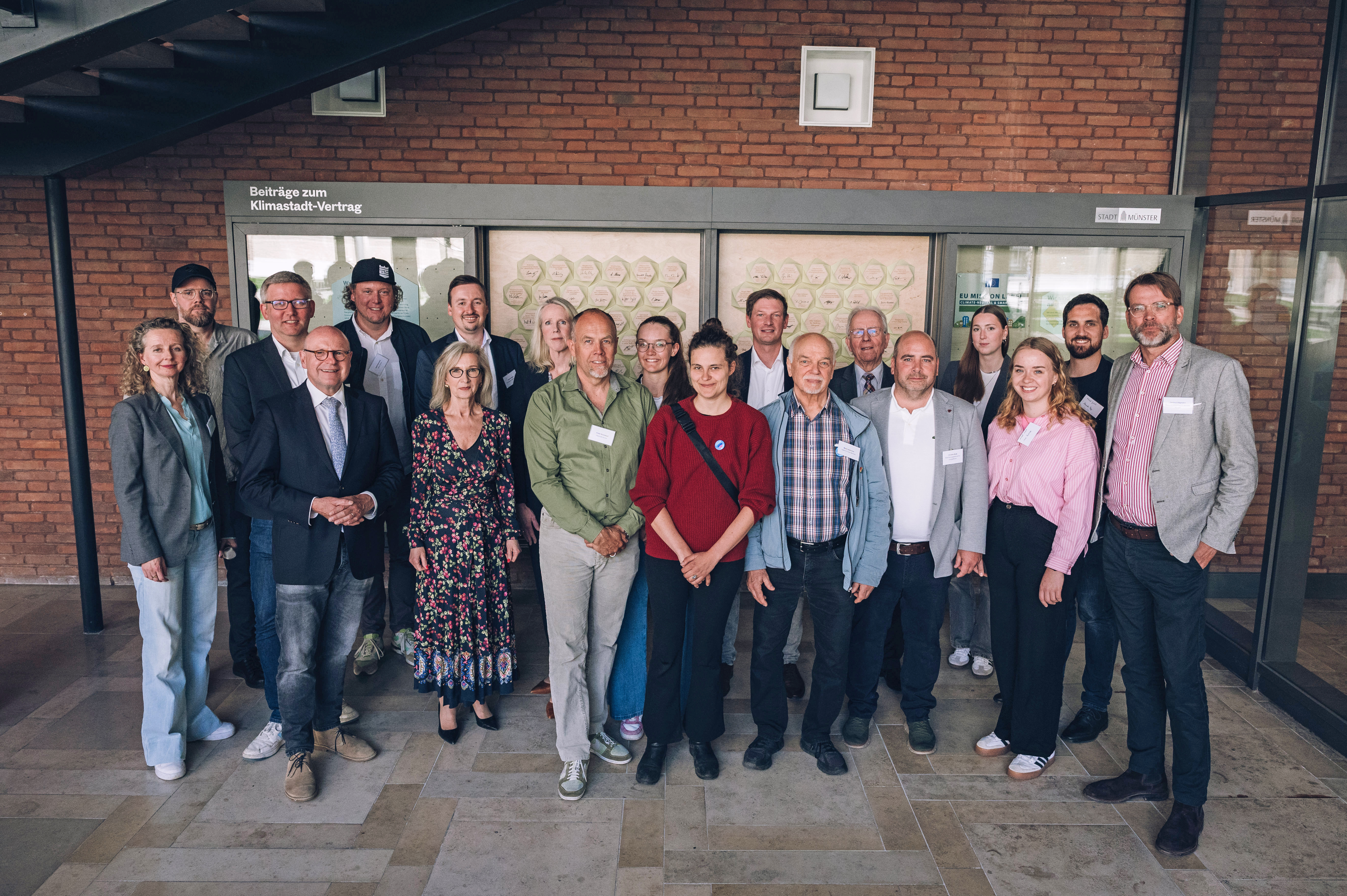 Gruppenfoto von Oberbürgermeister Markus Lewe sowie weiteren Engagierten, die neue Beiträge zum Klimastadt-Vertrag unterzeichnet haben