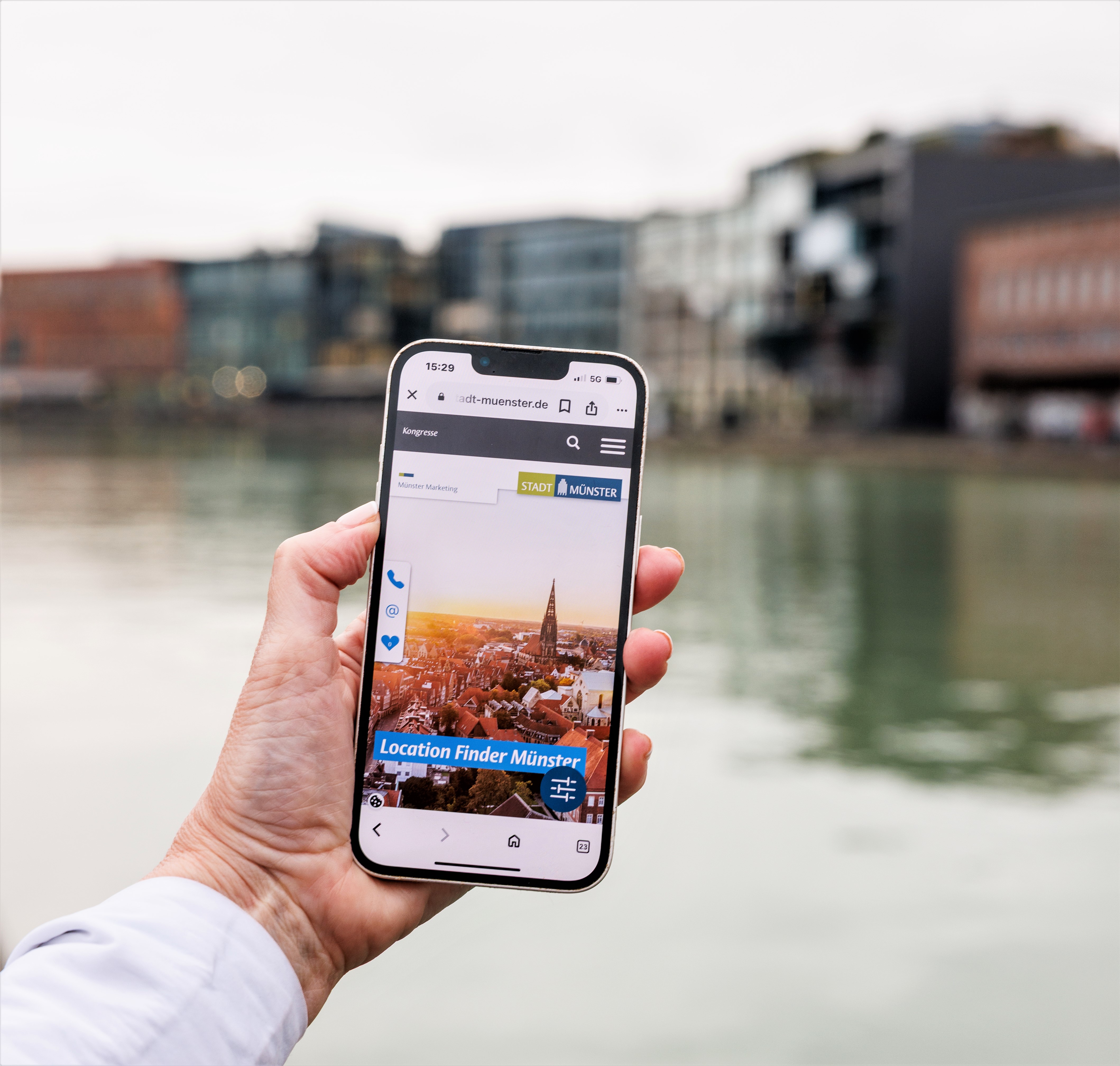 Eine Hand hält eine Smartphone, auf dem der digitale Location Finder geöffnet ist