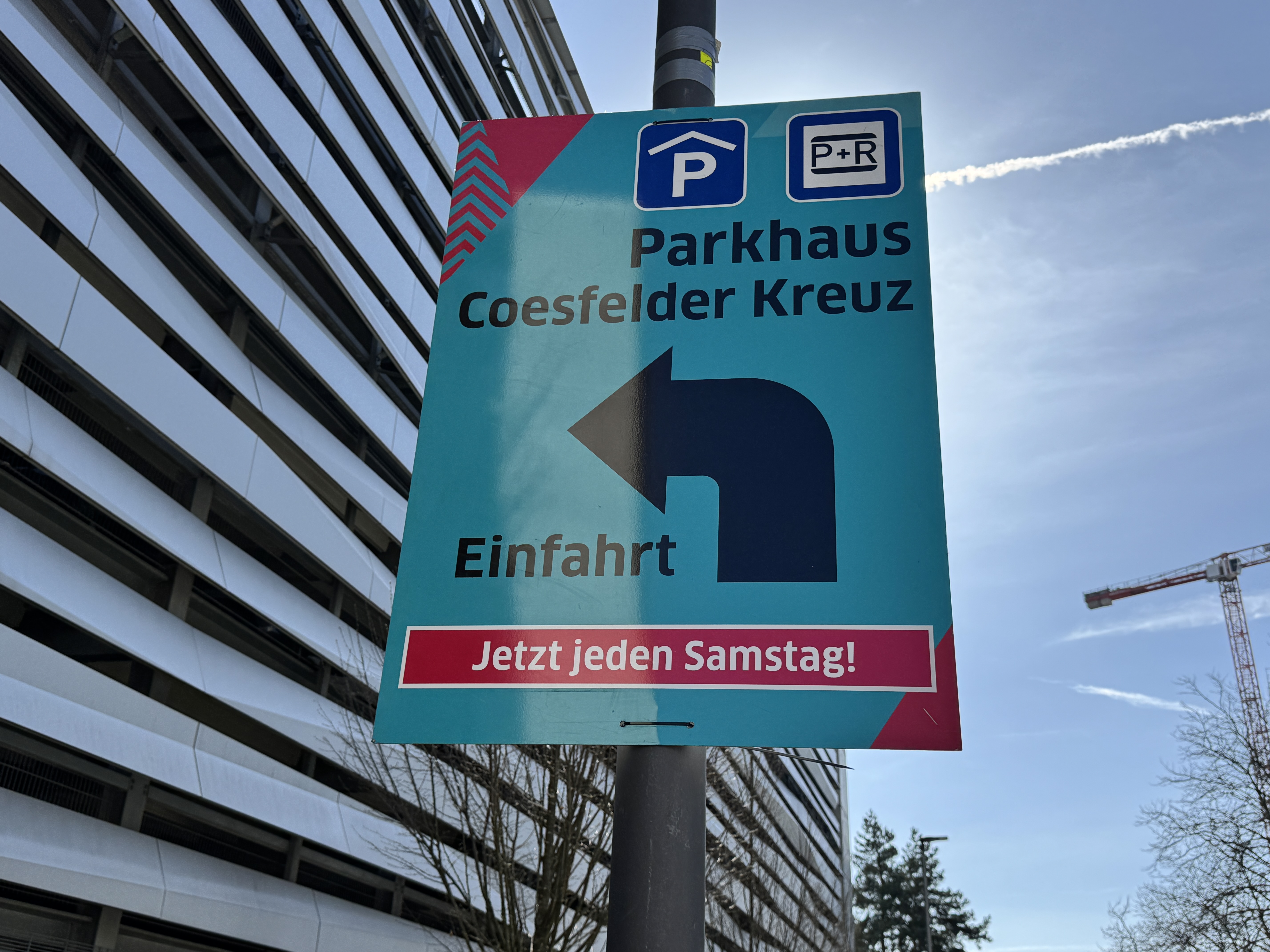 Ein Plakat an einem Laternenmast mit dem neuen Park+Ride-Angebot im Parkhaus am Coesfelder Kreuz.