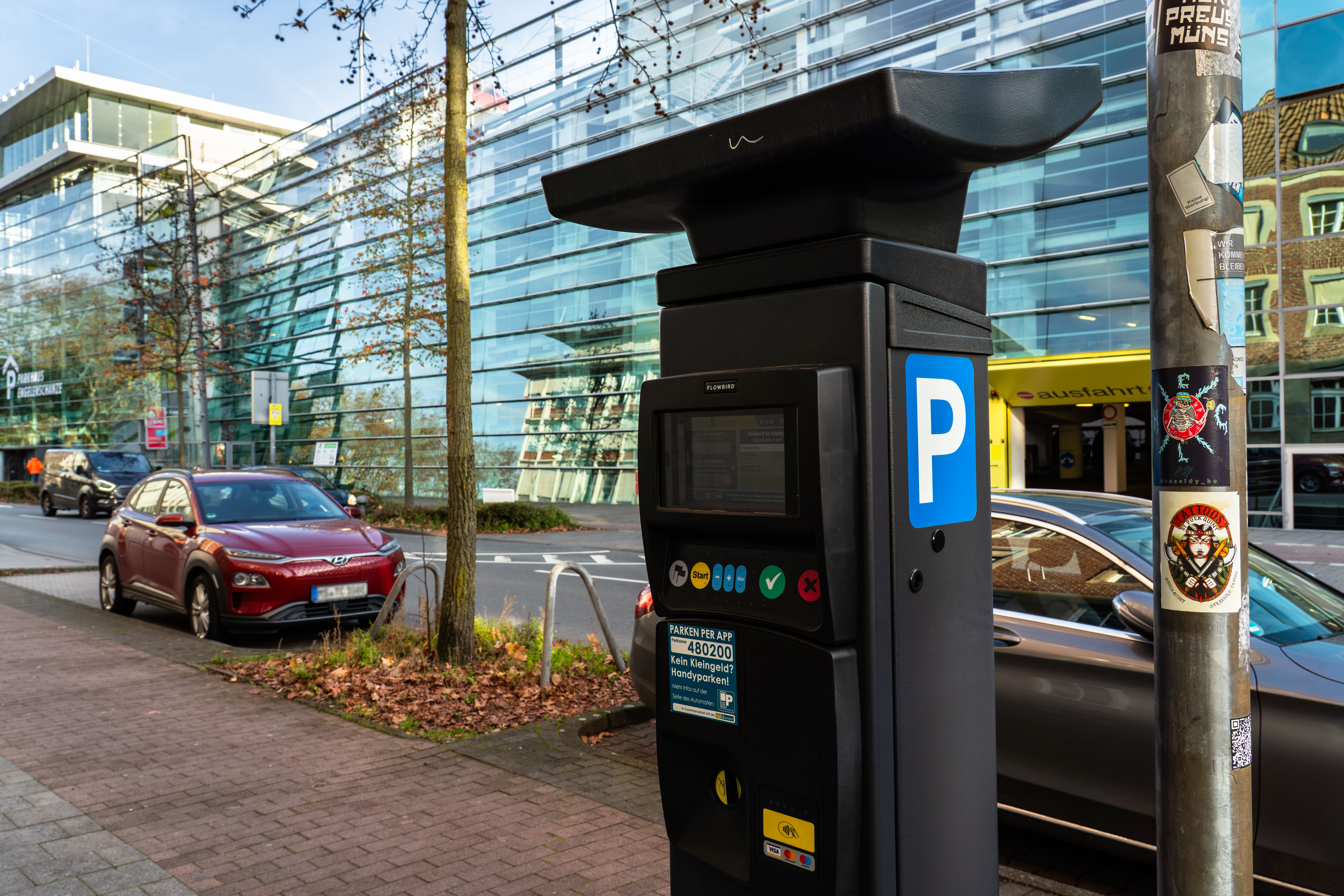 Parkautomat mit Autos im Hintergrund