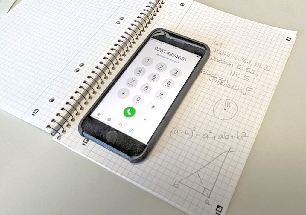 Ein Handy liegt auf einem Schulblock