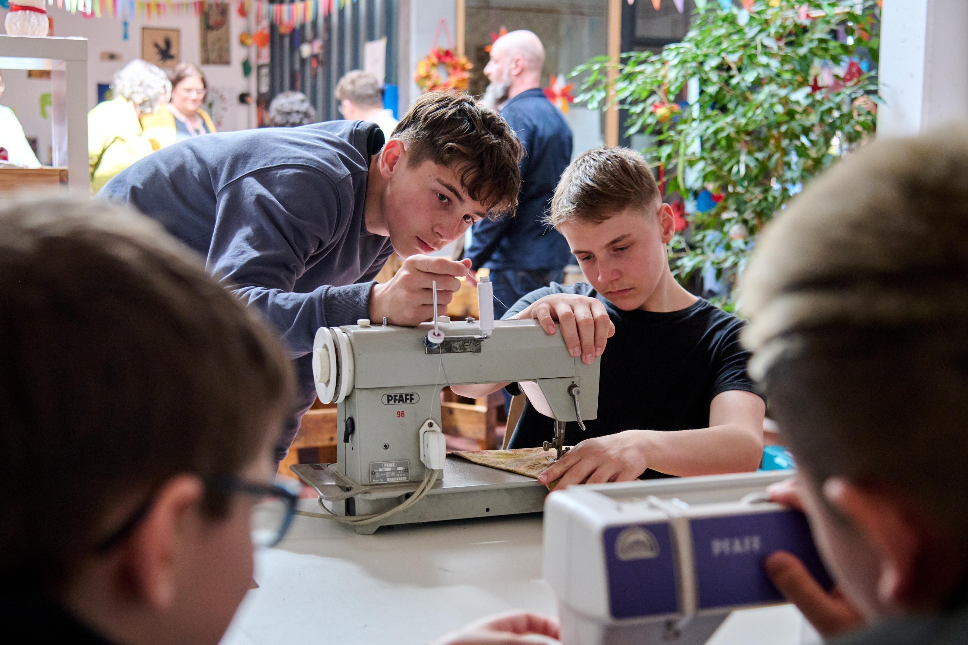 Zwei Jungen inspizieren eine Nähmaschine