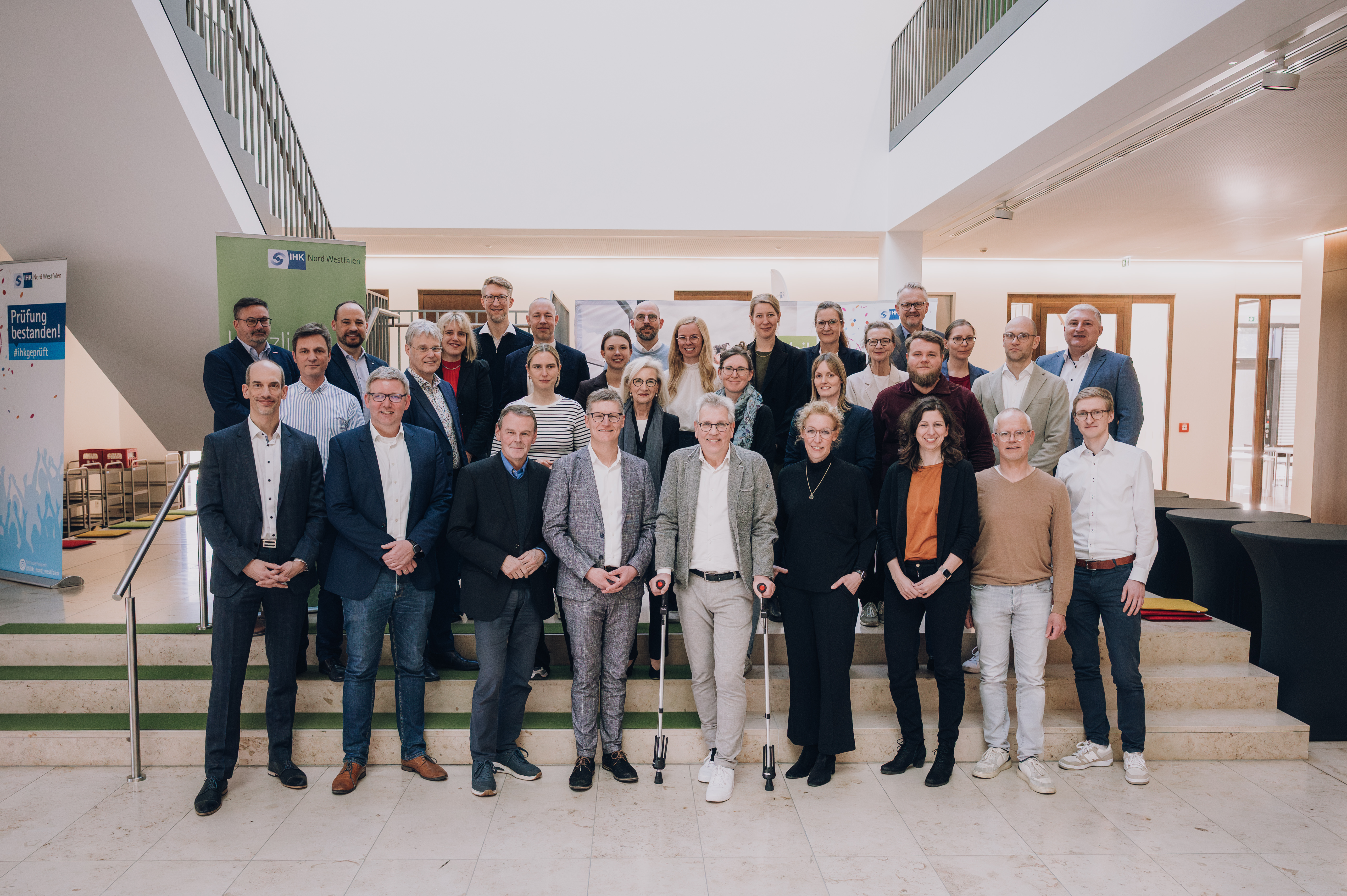Gruppenfoto mit vielen Personen in heller Halle vor großer Treppe. Oberbürgermeister Tilman Fuchs vorne 4.v.l., tauschte sich mit Vertreterinnen und Vertretern aus Wirtschaft und Wissenschaft aus. 