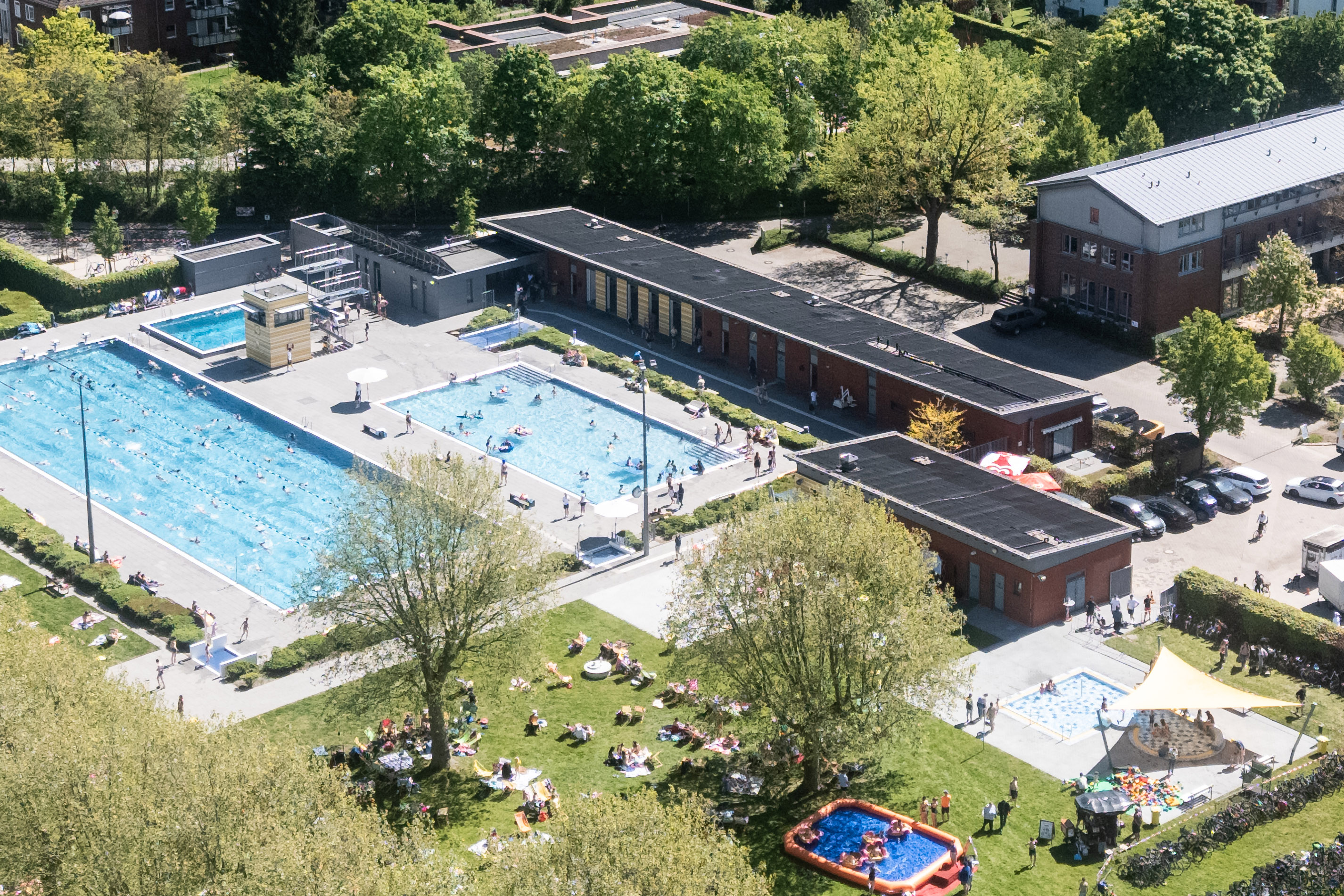 Ein Freibad von oben fotografiert. Zwei große Außenebecken und Wald darum sind zu sehen.