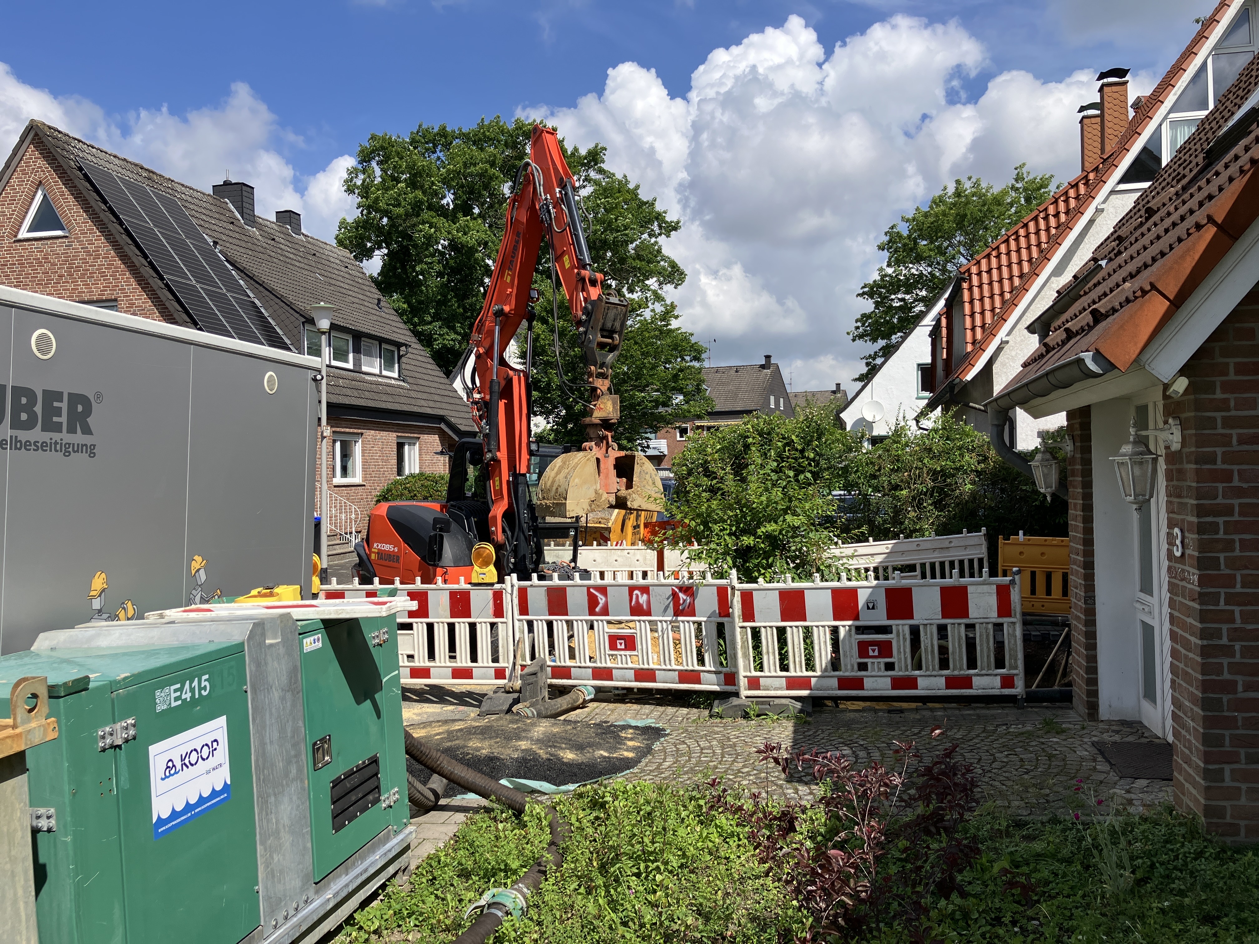 Kleiner Bagger und Absperrungen im Wohngebiet
