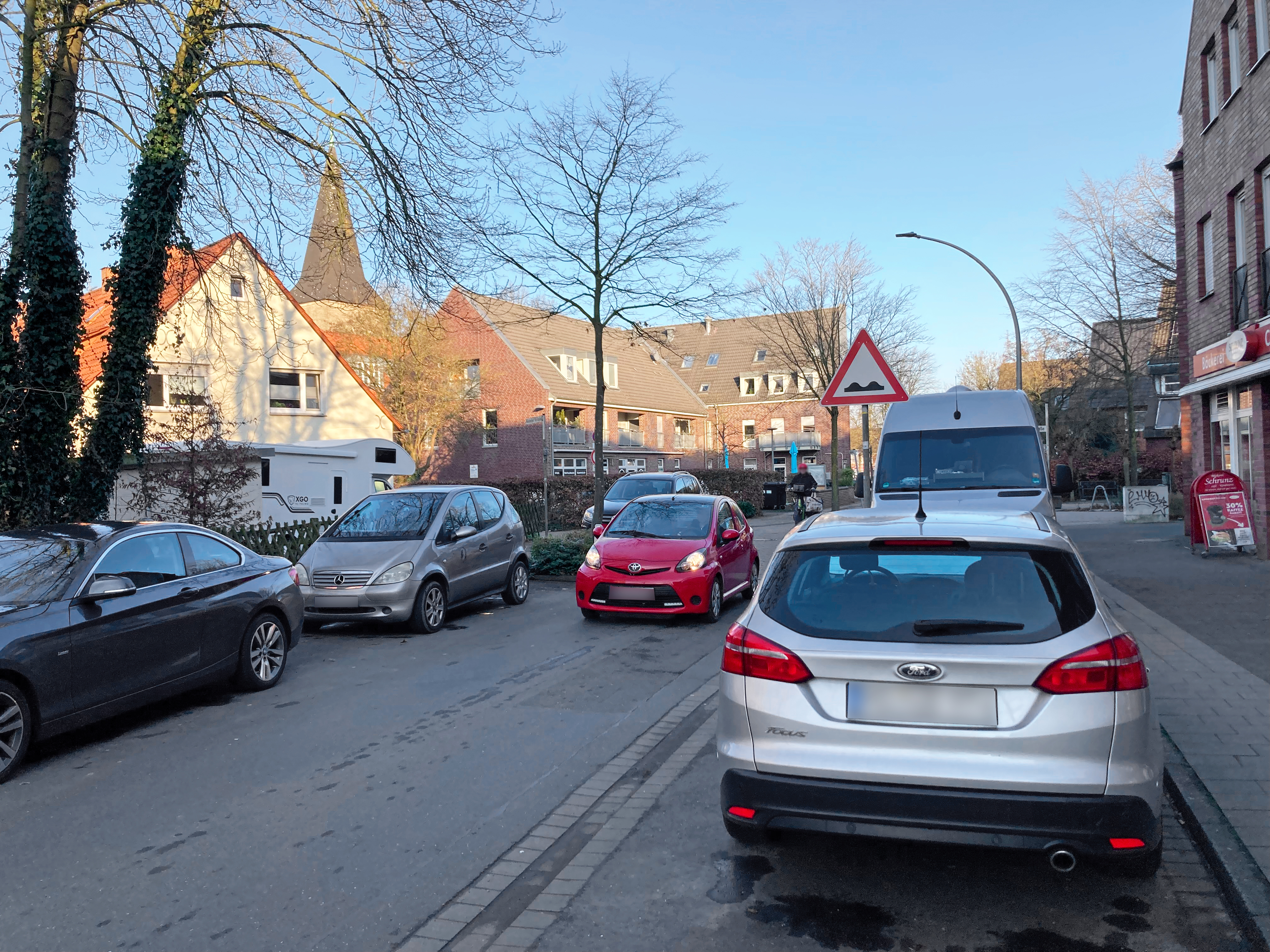 Enge Straße mit parkenden Autos an beiden Seiten