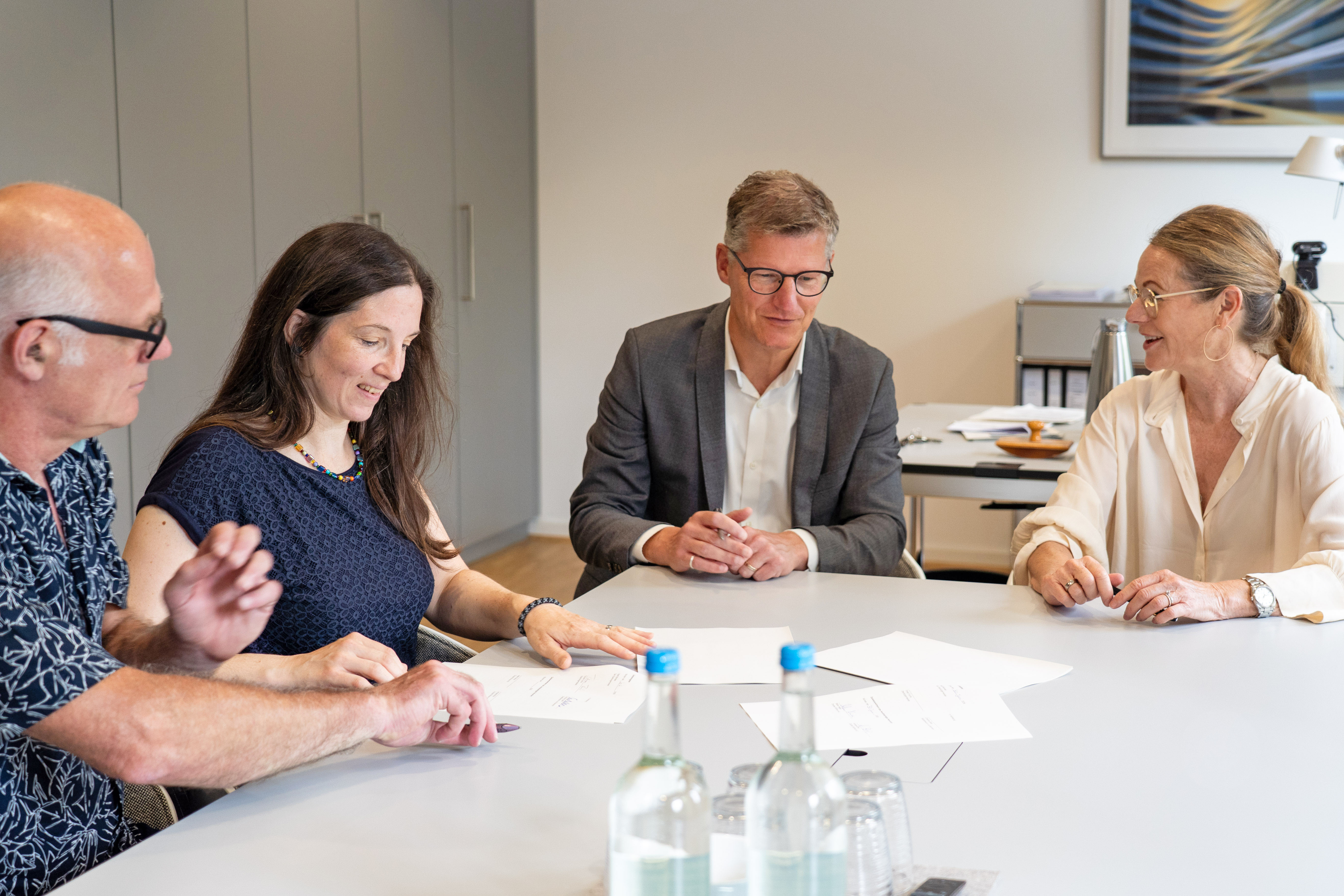 Stefan Hinze, Annalena Brix vom Vorstand der Genossenschaft und Oberbürgermeister Tilman Fuchs und Stadtdirektorin Christine Zeller sitzen gemeinsam an einem Tisch bei der Vertragsunterzeichnung