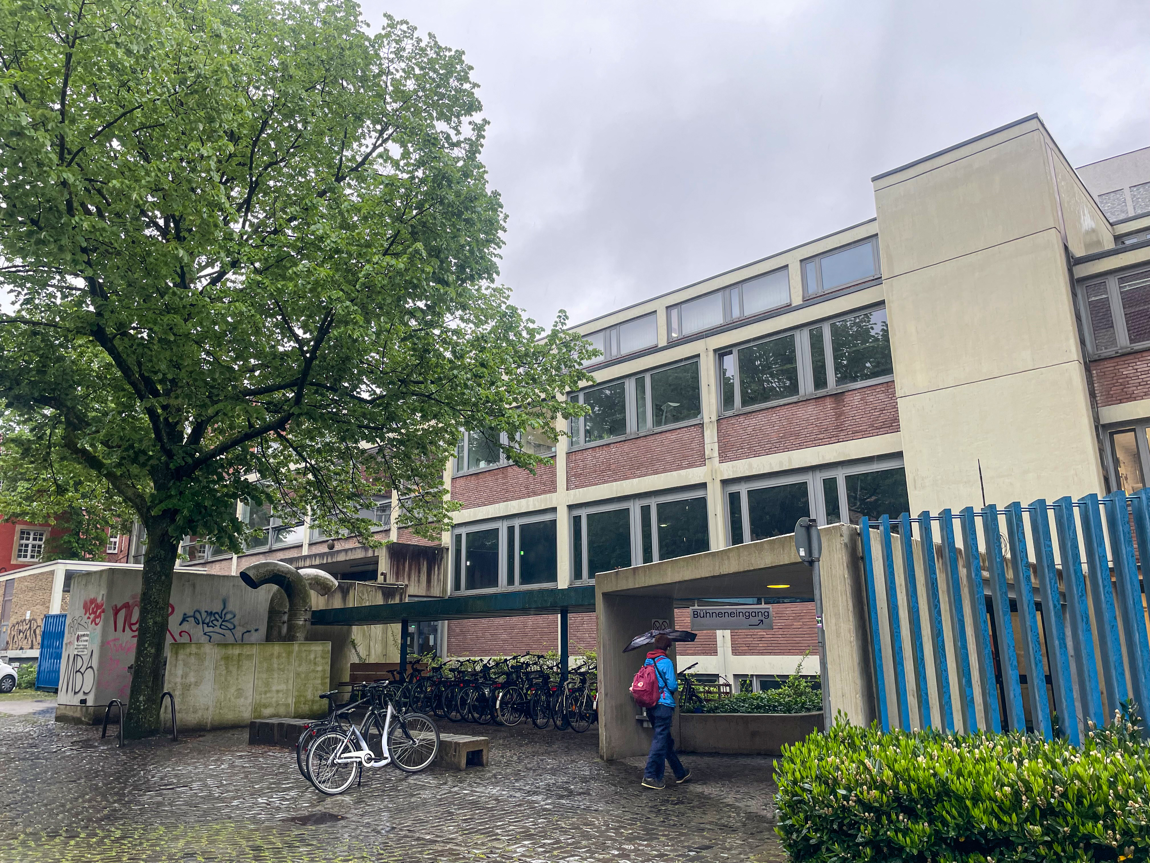 Blick auf ein zweistöckiges Gebäude aus Beton und roten Klinkern.