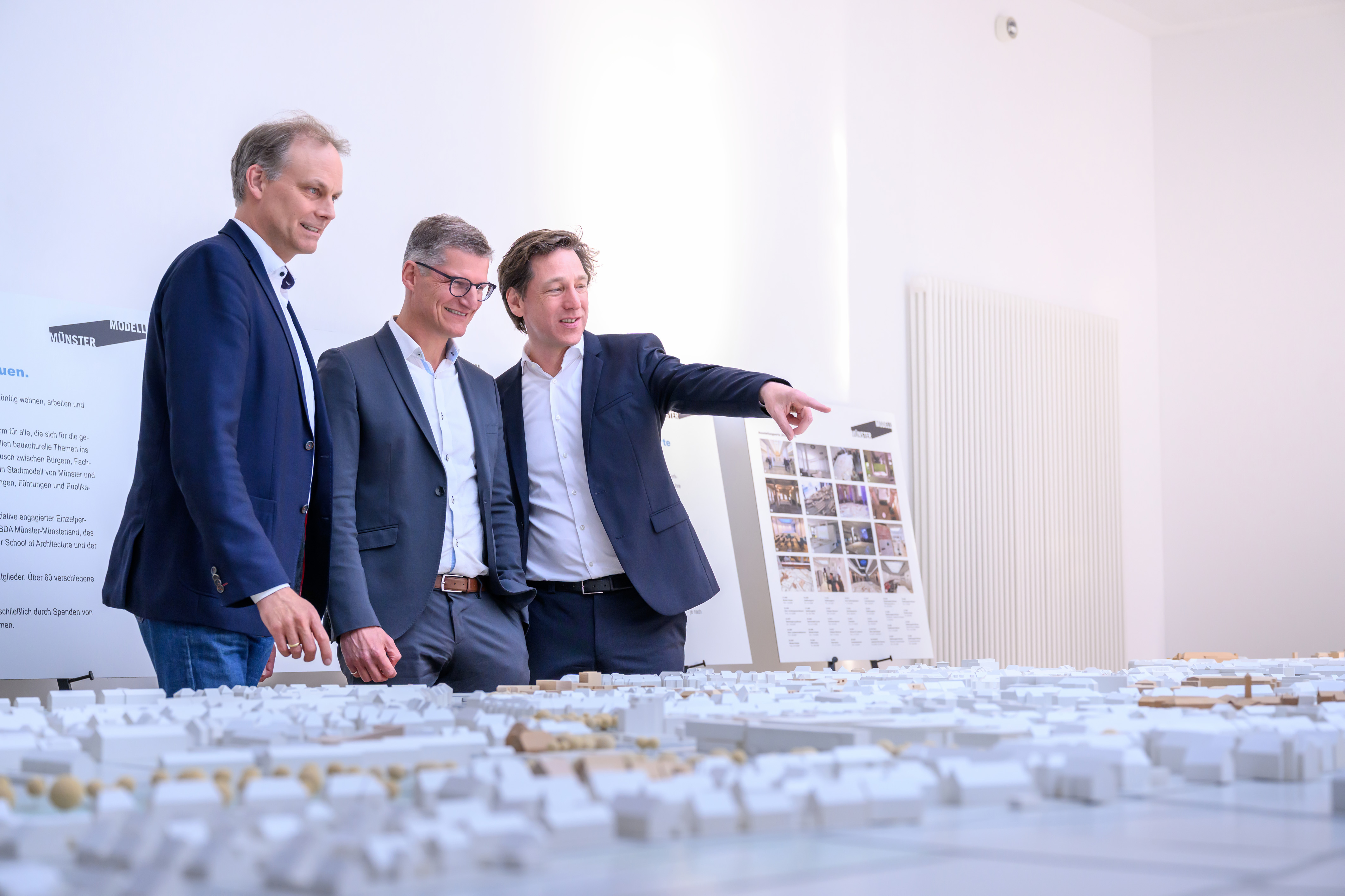 Oberbürgermeister Tilman Fuchs (in der Bildmitte) mit dem Vorsitzenden des Vereins Münster Modell e.V., Stefan Rethfeld, und Christopher Festersen, Leiter des Stadtplanungsamtes stehen am Münster Modell.