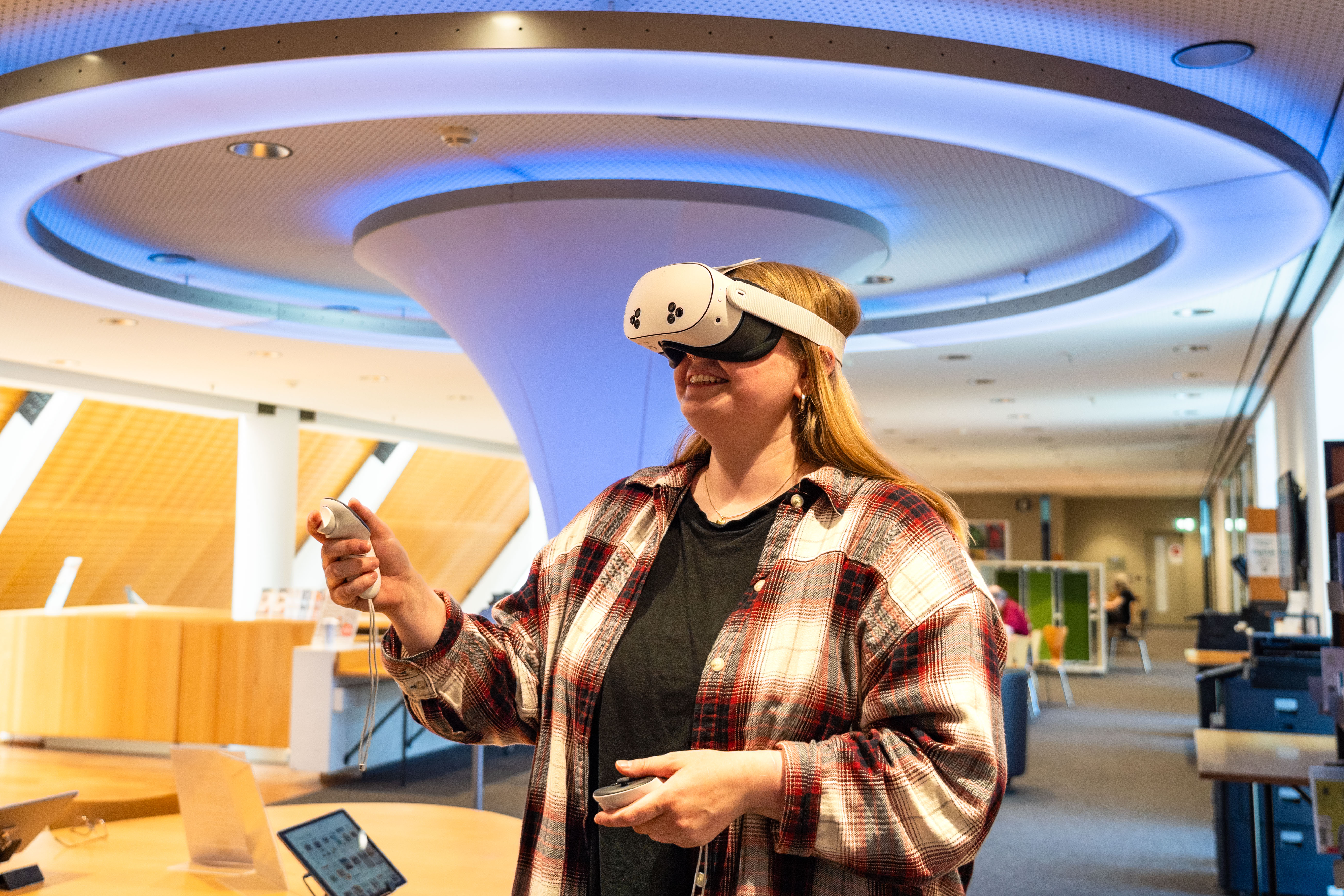 Junge Frau verwendet VR-Brille in der Stadtbücherei