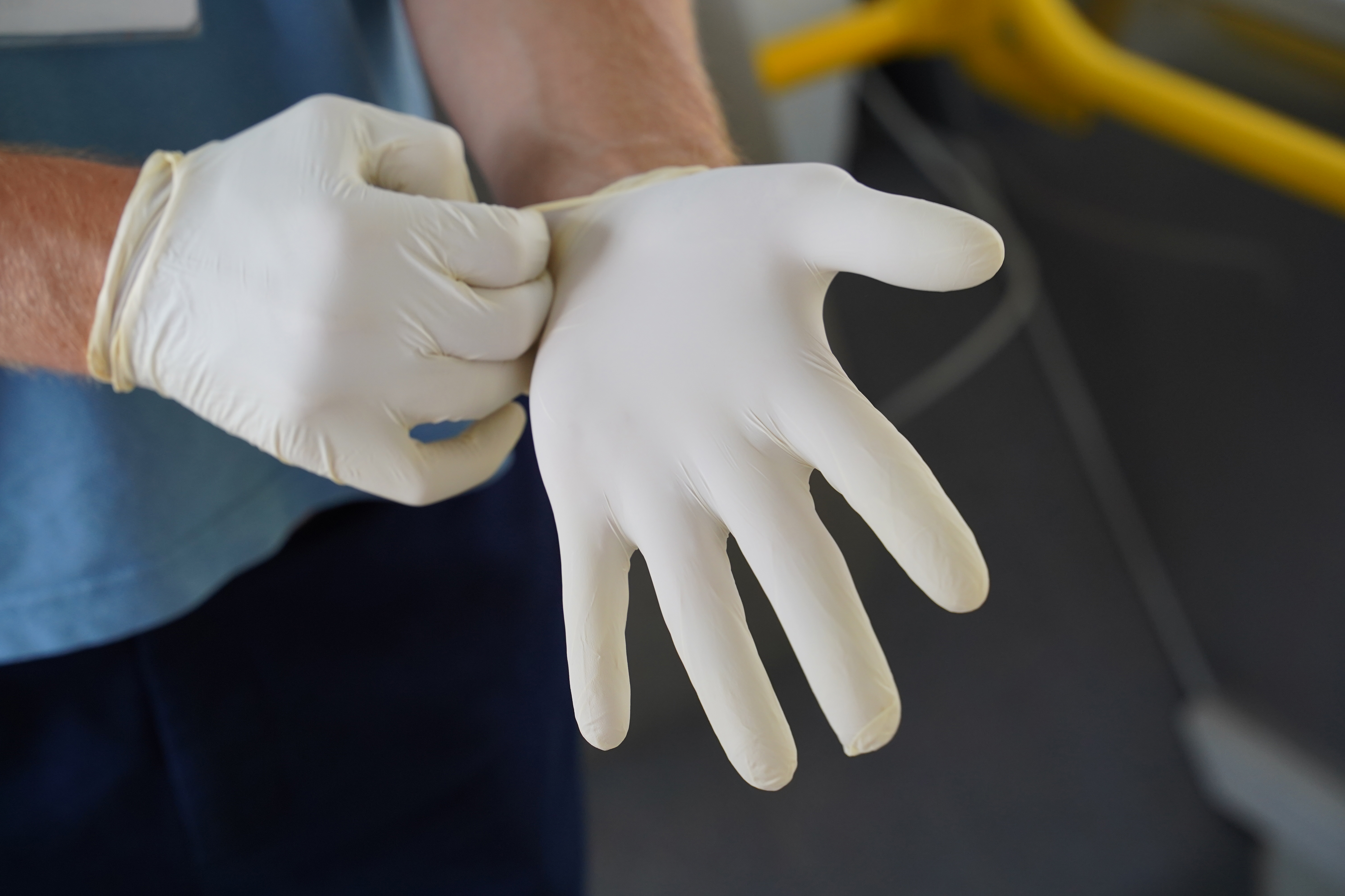 Medizinische Fachkraft zieht Handschuhe über