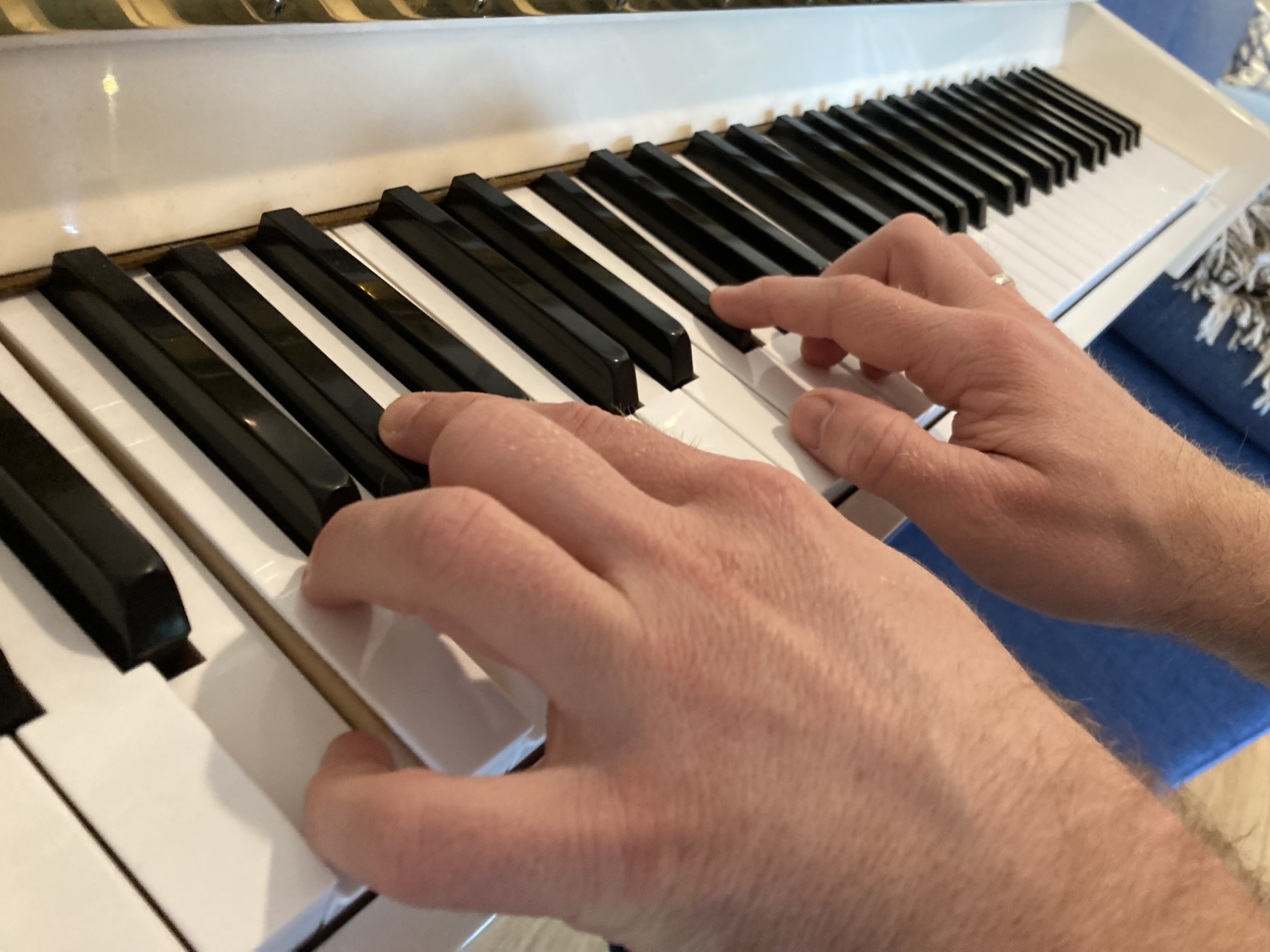 Klaviertasten und Hände, die darauf spielen