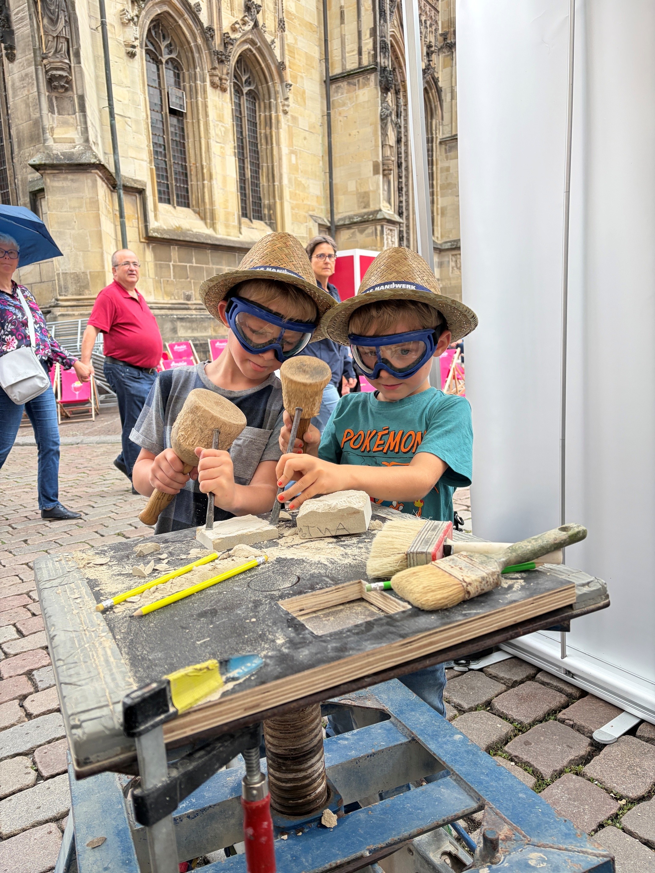Zwei Jungs probieren sich als Steinmetze aus.