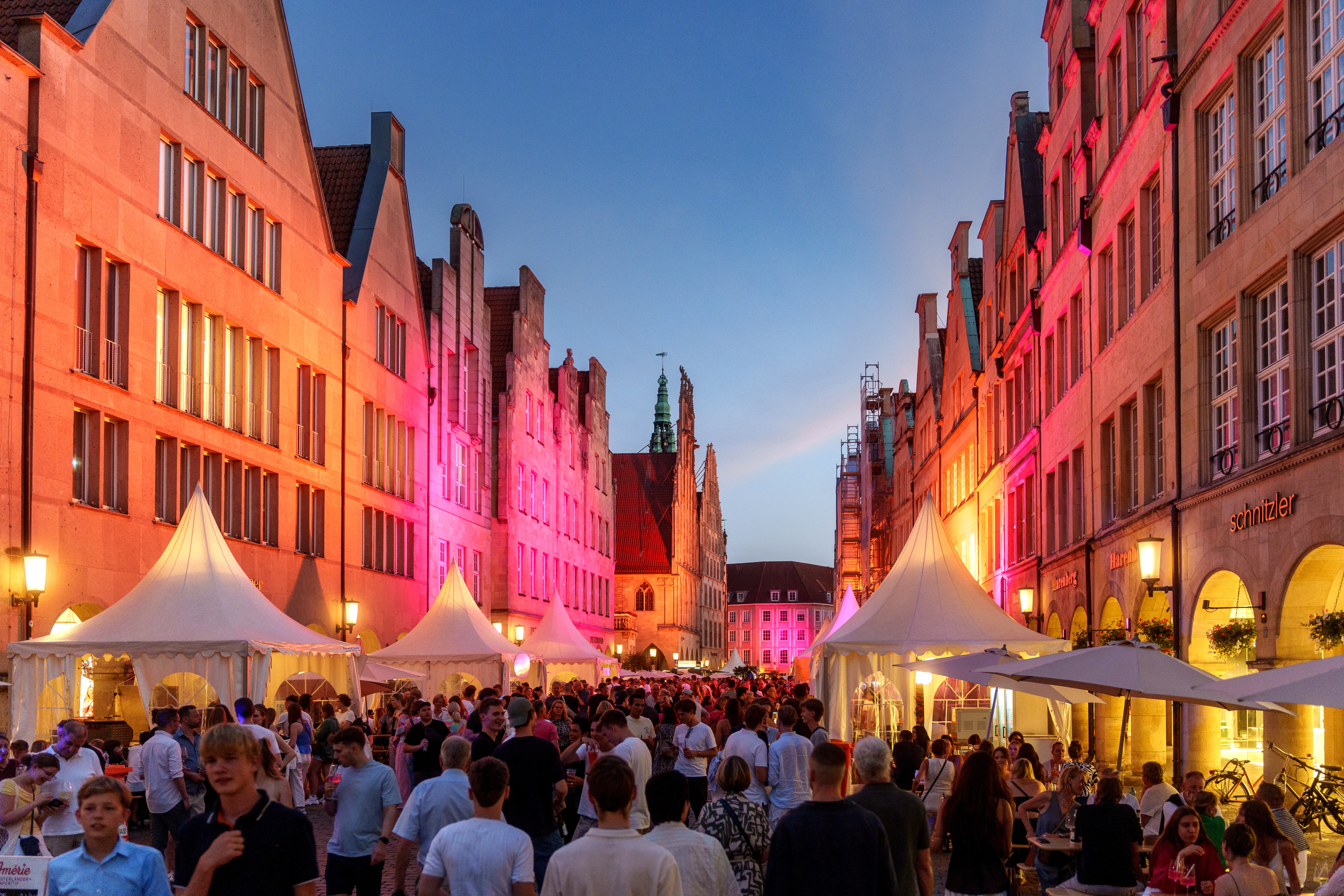 Viele Menschen beim Stadtfest auf dem Prinzipalmarkt. Die Giebelhäser sind bunt beleuchtet.