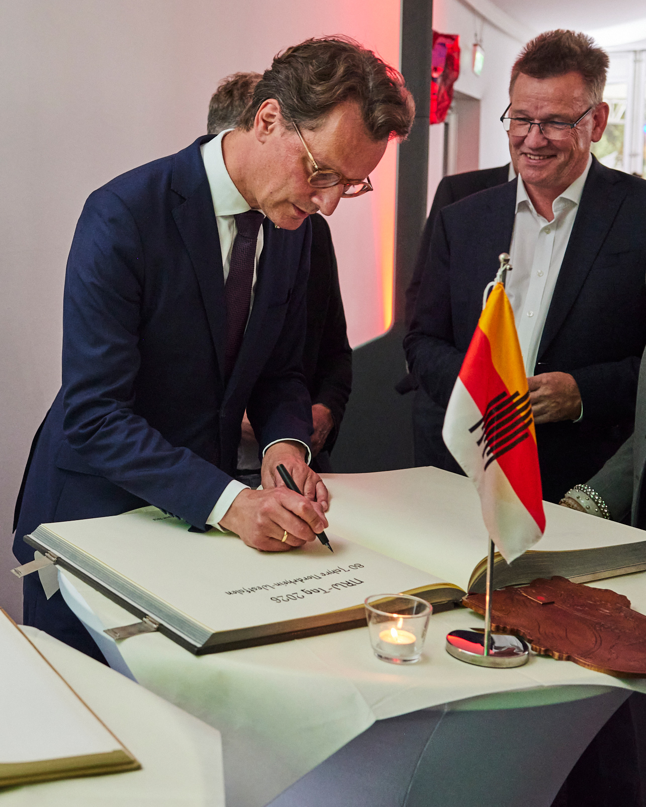 NRW-Ministerpräsident Hendrik Wüst trägt sich ins Goldene Buch der Stadt ein.