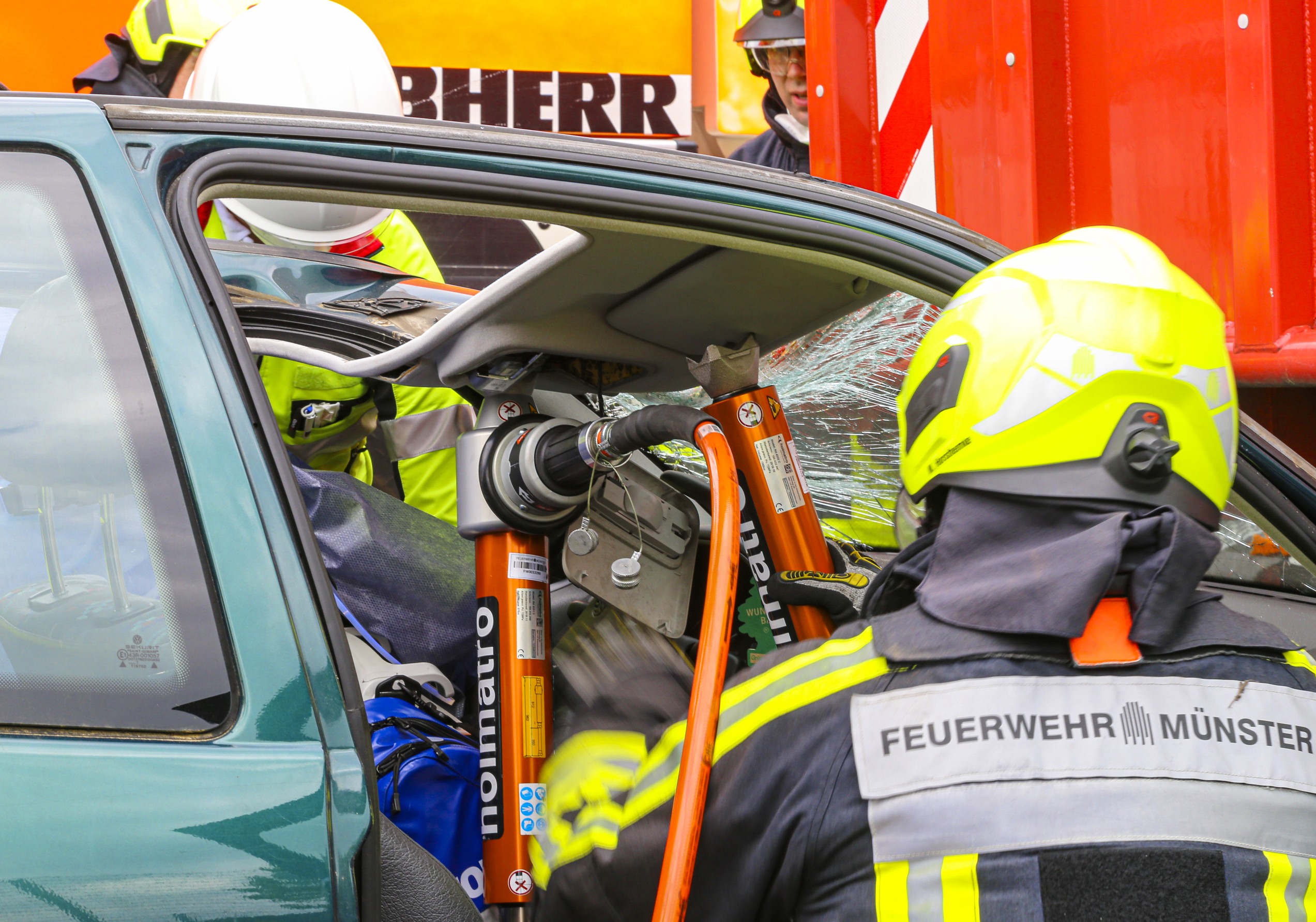 Simulation eines Verkehrsunfalls: Ein Feuerwehrmann schneidet mit Spezialwerkzeug ein Auto auf.