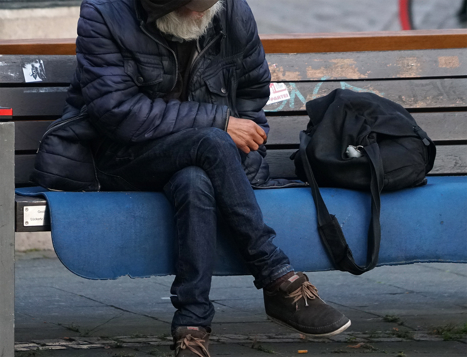 Eine Person sitzt auf einer Bank