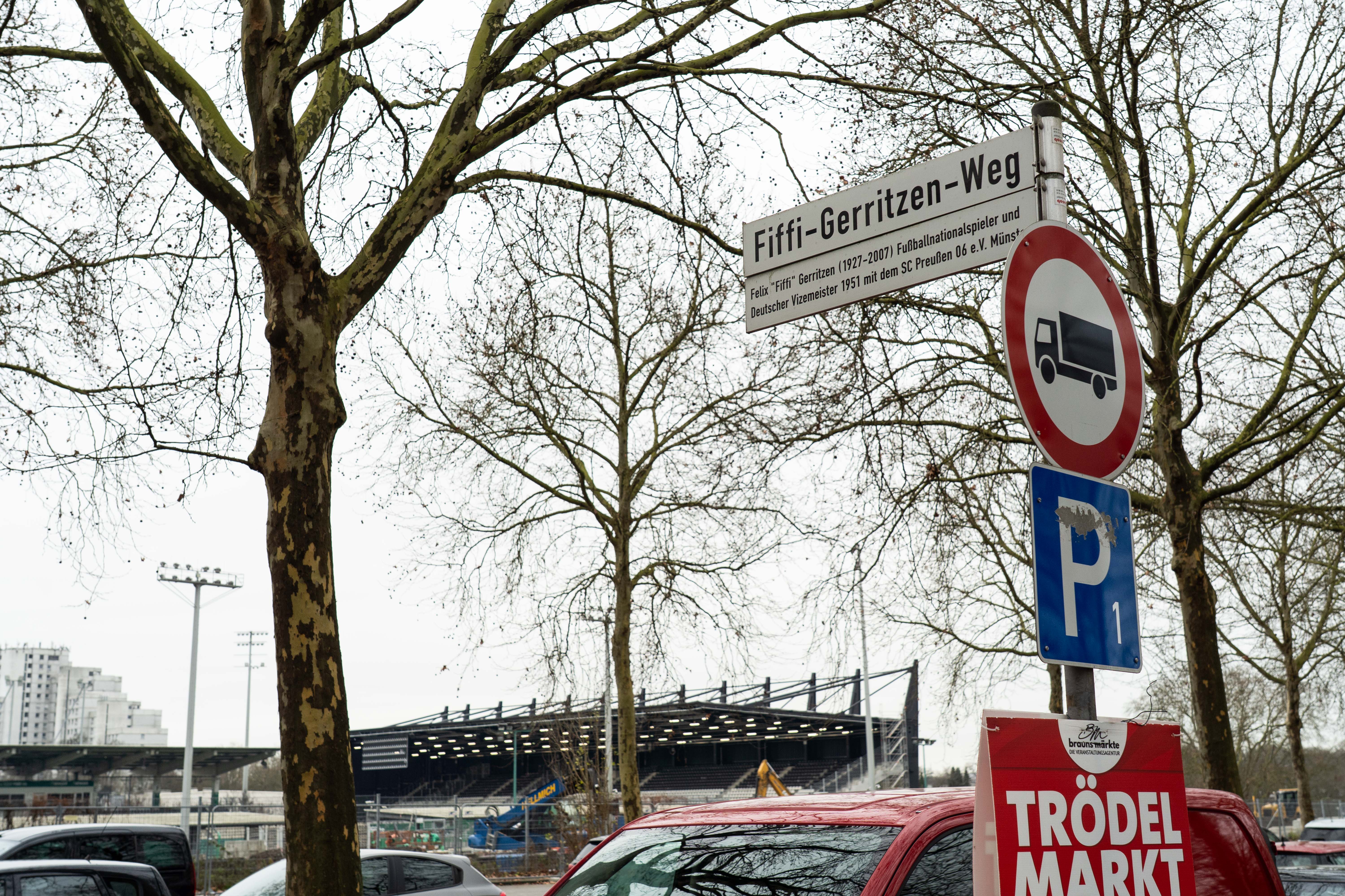 Straßenschild des Fiffi-Gerritzen-Weg mit dem Stadion im Hintergrund