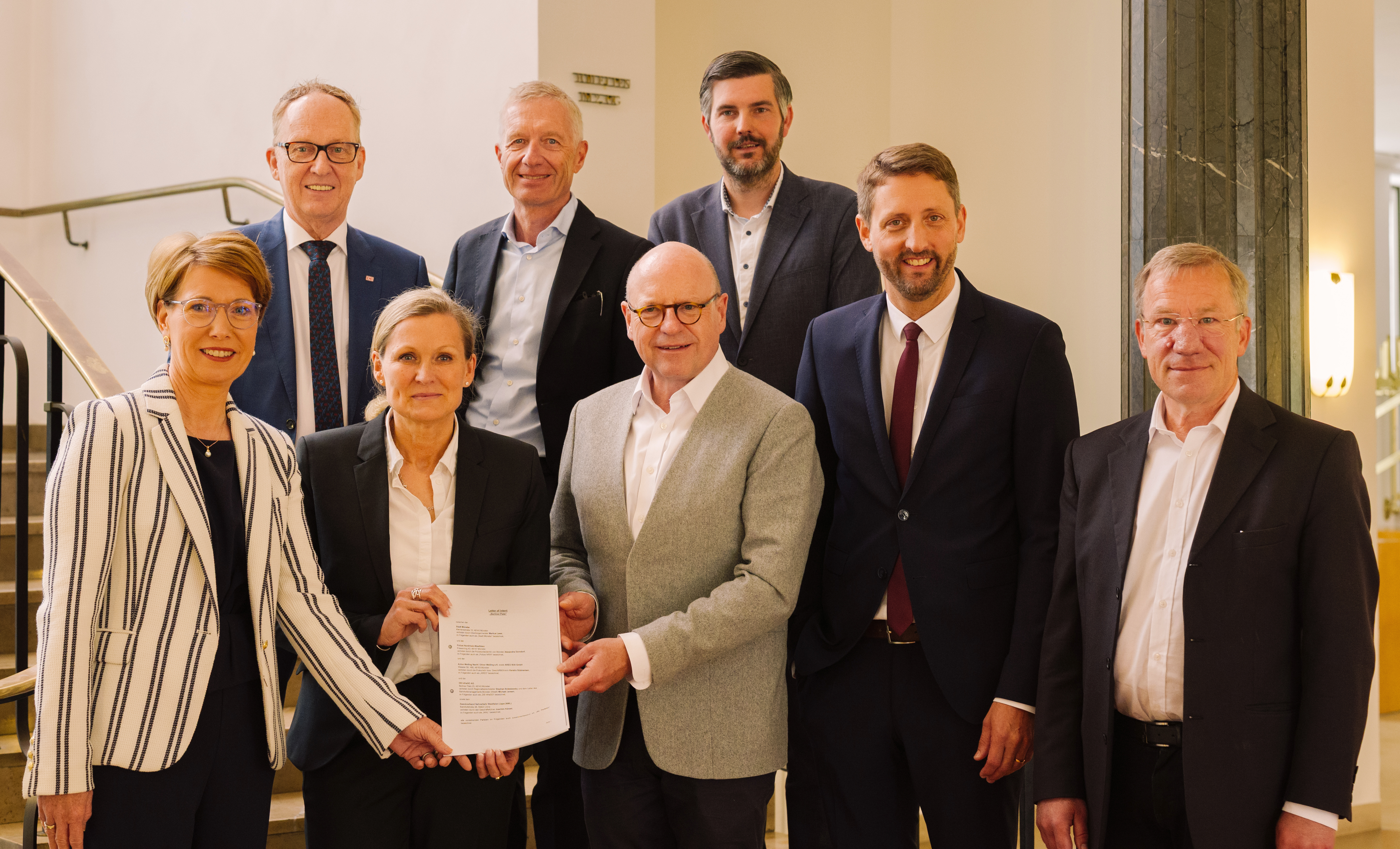 Acht Personen halten die Absichtserklärung