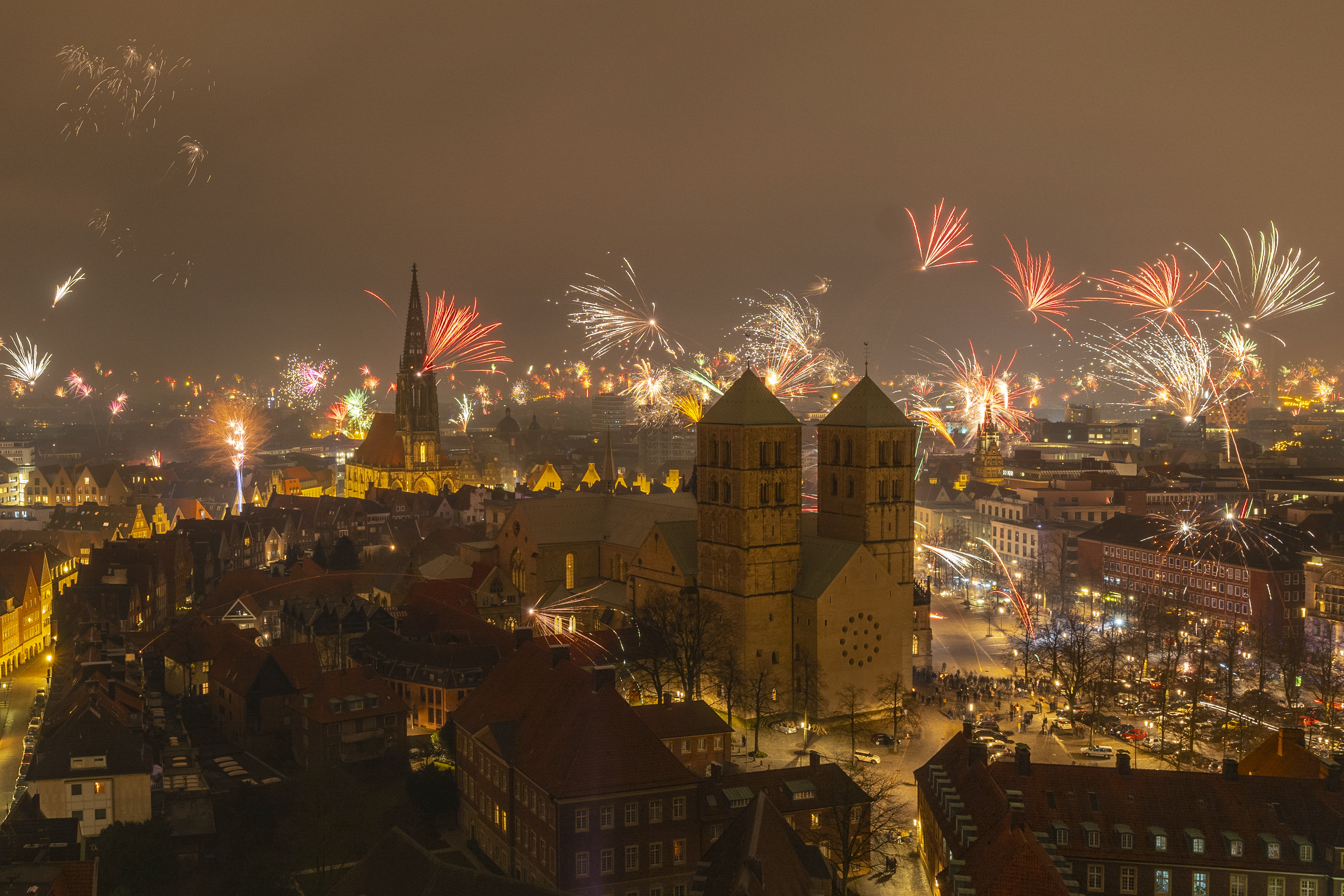 Feuerwerk über den Dächern Münsters; im Vordergrund der Domplatz