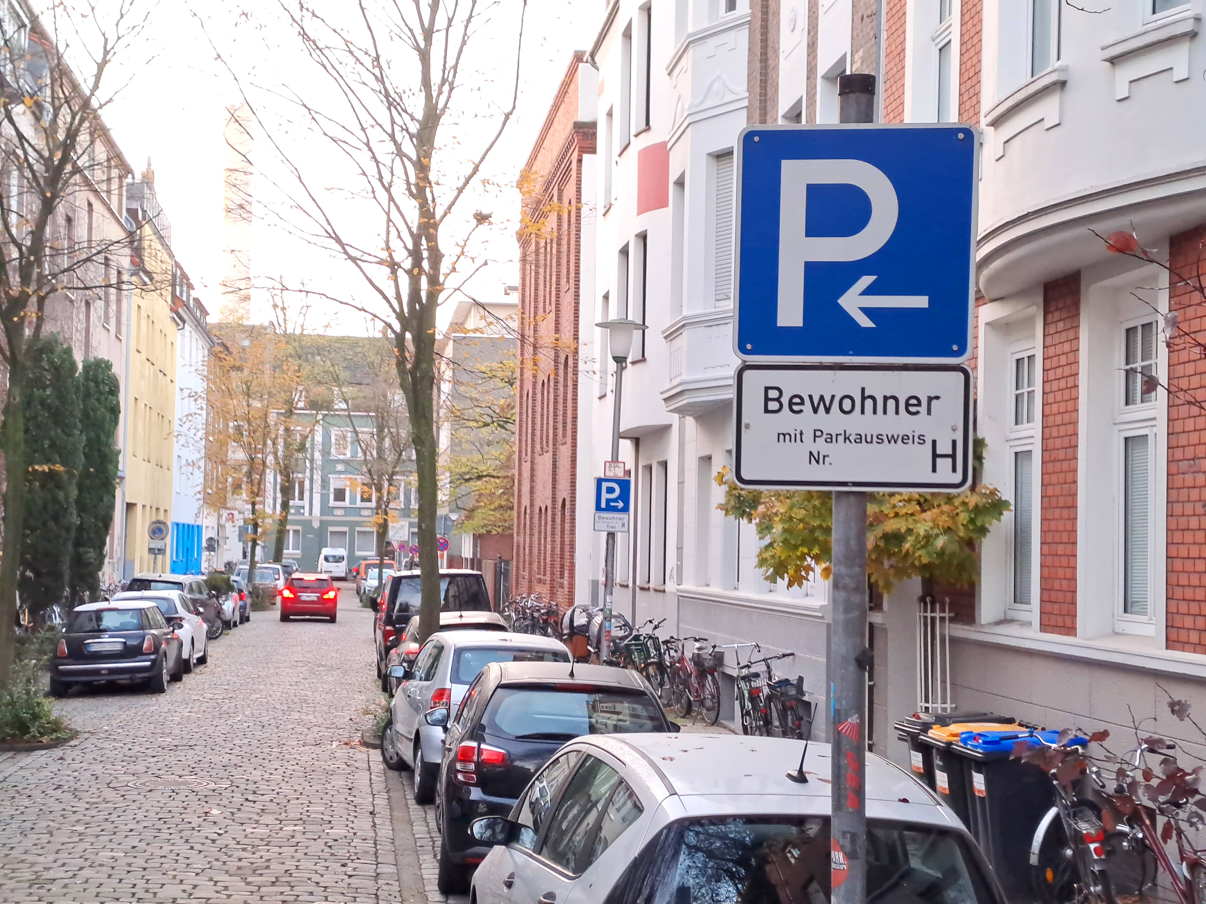 Parkende Autos in einer Straße; vorne ein Schild mit der Aufschrift "Bewohnerparken"