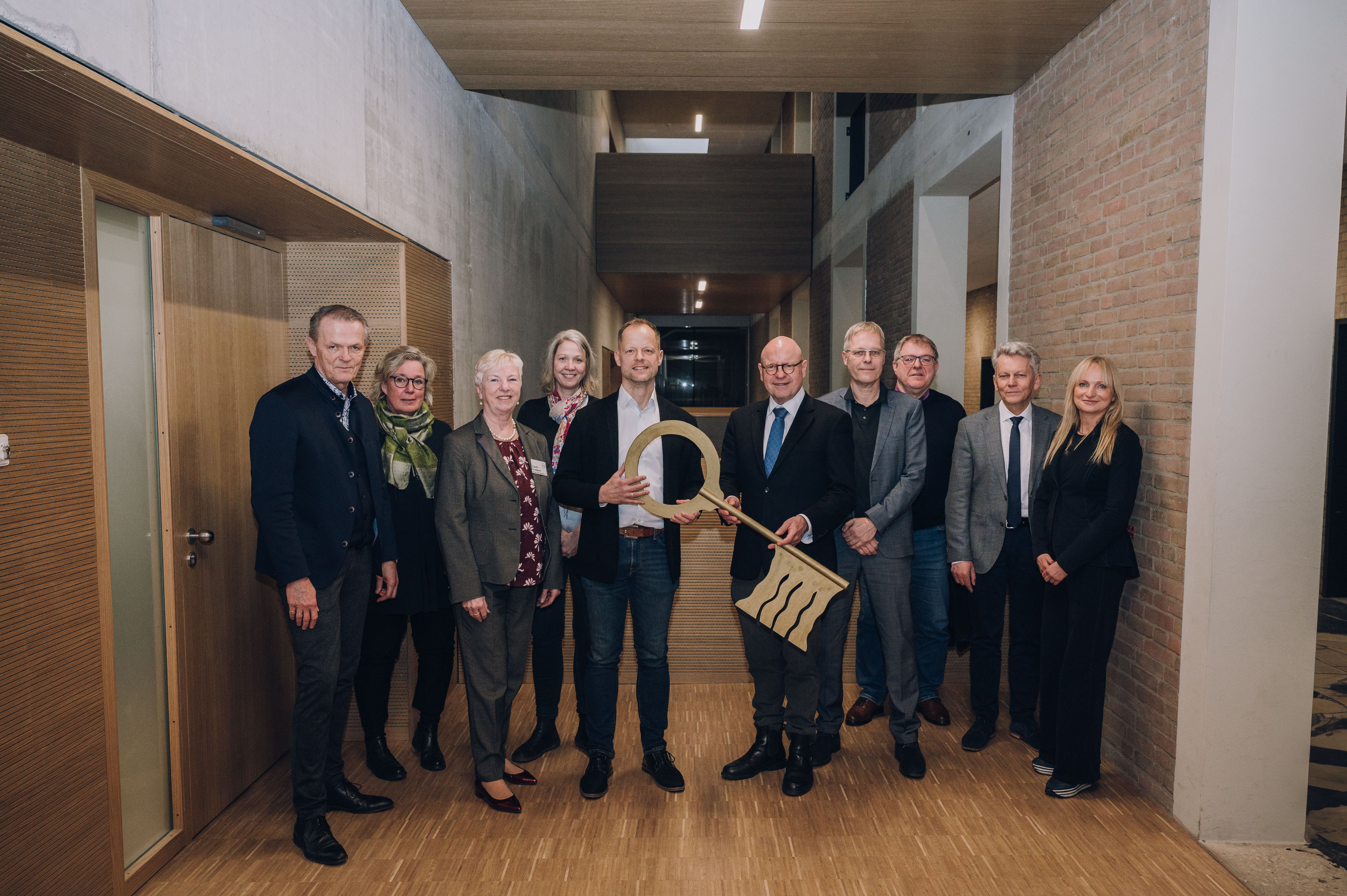 Oberbürgermeister Markus Lewe (6.v.l.) übergab im Beisein von weiteren Beteiligten den symbolischen Schlüssel an Schulleiter Michael Rotterdam (5.v.l.). 