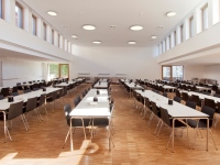 Großer Raum mit Oberlichtern, Parkettfußboden und langen Tischreihen