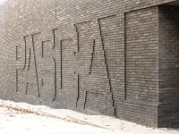 Außenwand - die Klinkersteine zeigen im Relief den Schriftzug 
'PASCAL'