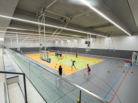 Blick in die Sporthalle mit Ballspielfeld und Tribüne