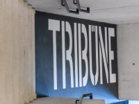 Wand hinter der Tribüne, auf blauem Grund steht in weißer Schrift 'TRIBÜNE'