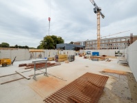 Blick in die Baustelle: Betonwände, Armierungsstahl und Baukran