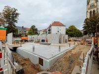 Blick auf die Baustelle: Keller mit gegossener Betondecke, erste Wände stehen.