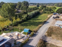 Vorn der Spielplatz der Kita, daneben eine Straße, im Hintergrund ein Baukran und Baufahrzeuge