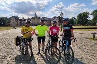 Gruppenbild, vier Personen vor dem Unischloss mit den Fahrrädern