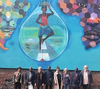 Gruppenbild mit Gästen aus Tamale vor der bemalten Hauswand