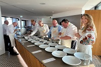 Gruppenbild, lächelnde Menschen tragen Schürzen