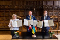 Hall of Peace, three people holding certificates in their hands