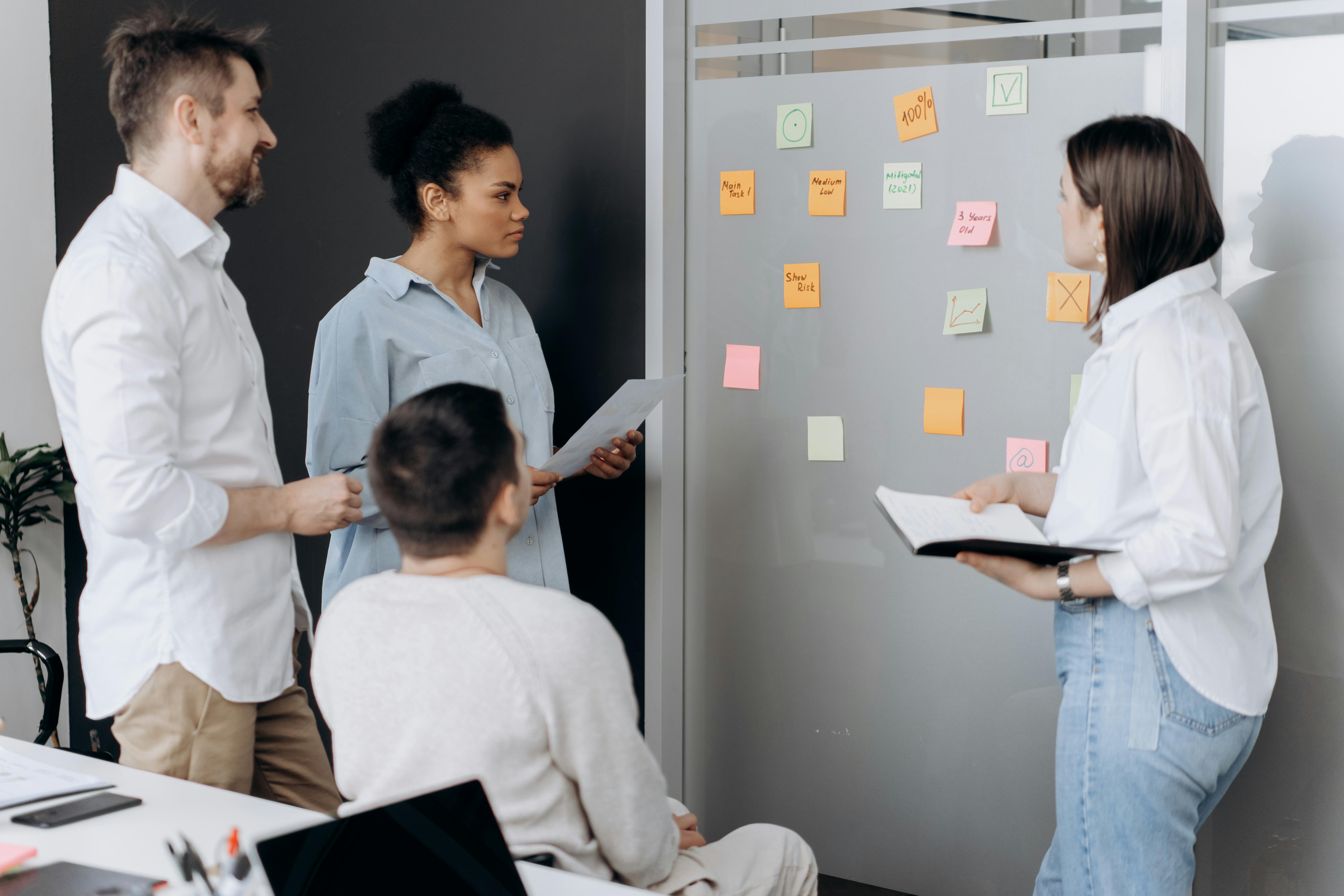 Ein Team von mehreren Personen steht vor einer Pinnwand