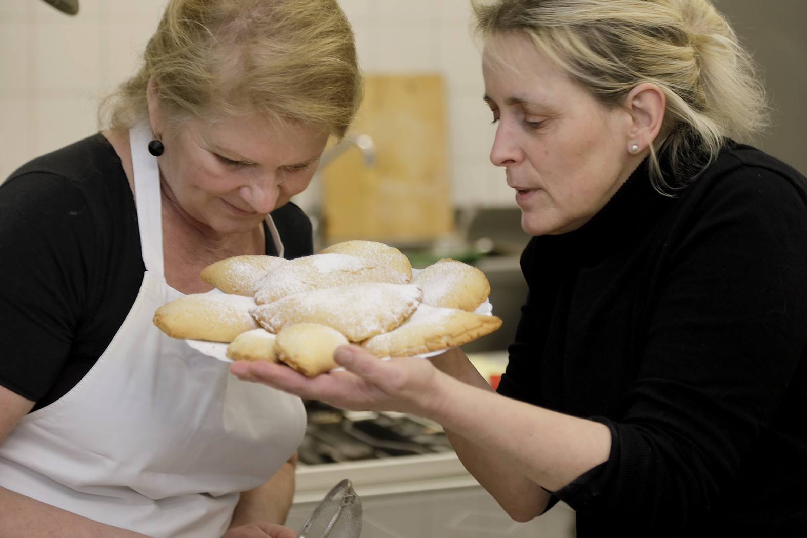 Zwei blonde Frauen betrachten selbstgebackenes weißes Brot