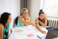 Drei Studierenede bei der Projektarbeit am Computer